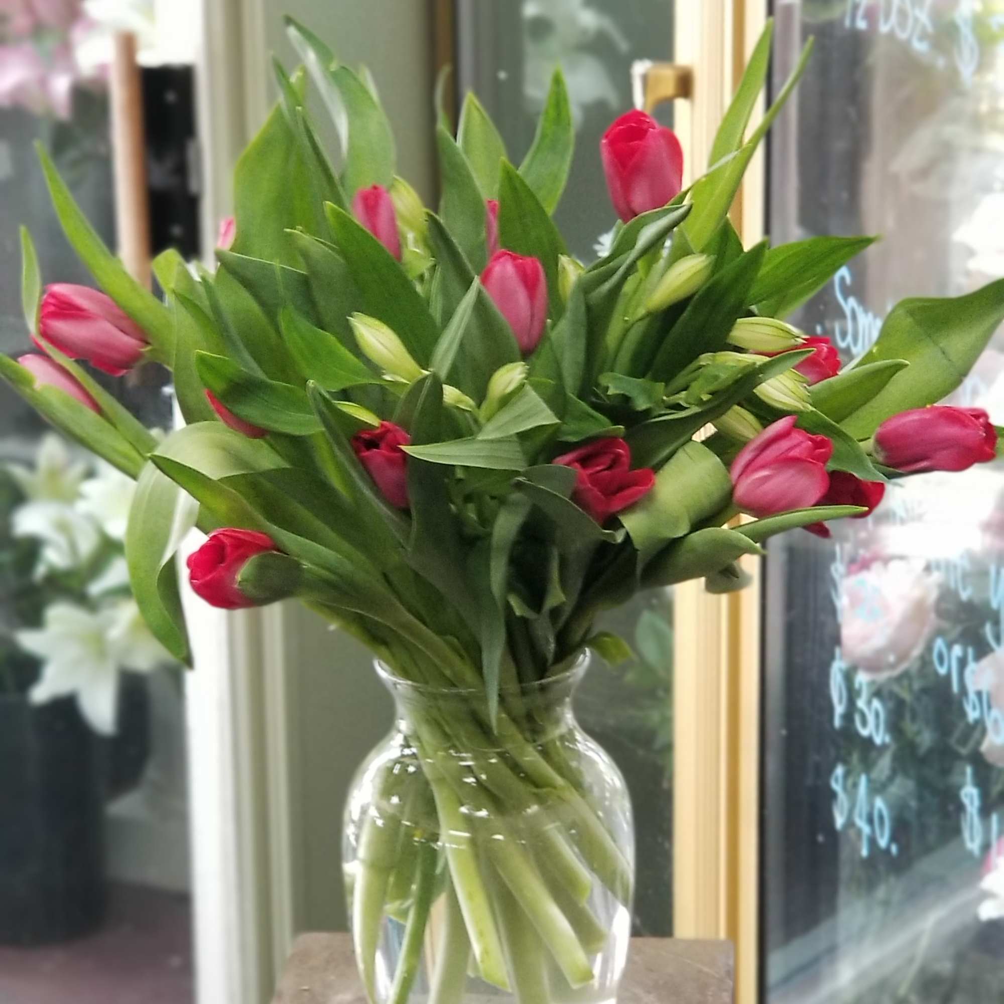 Pink tulips arranged in a clear glass vase, photo 3 of 3