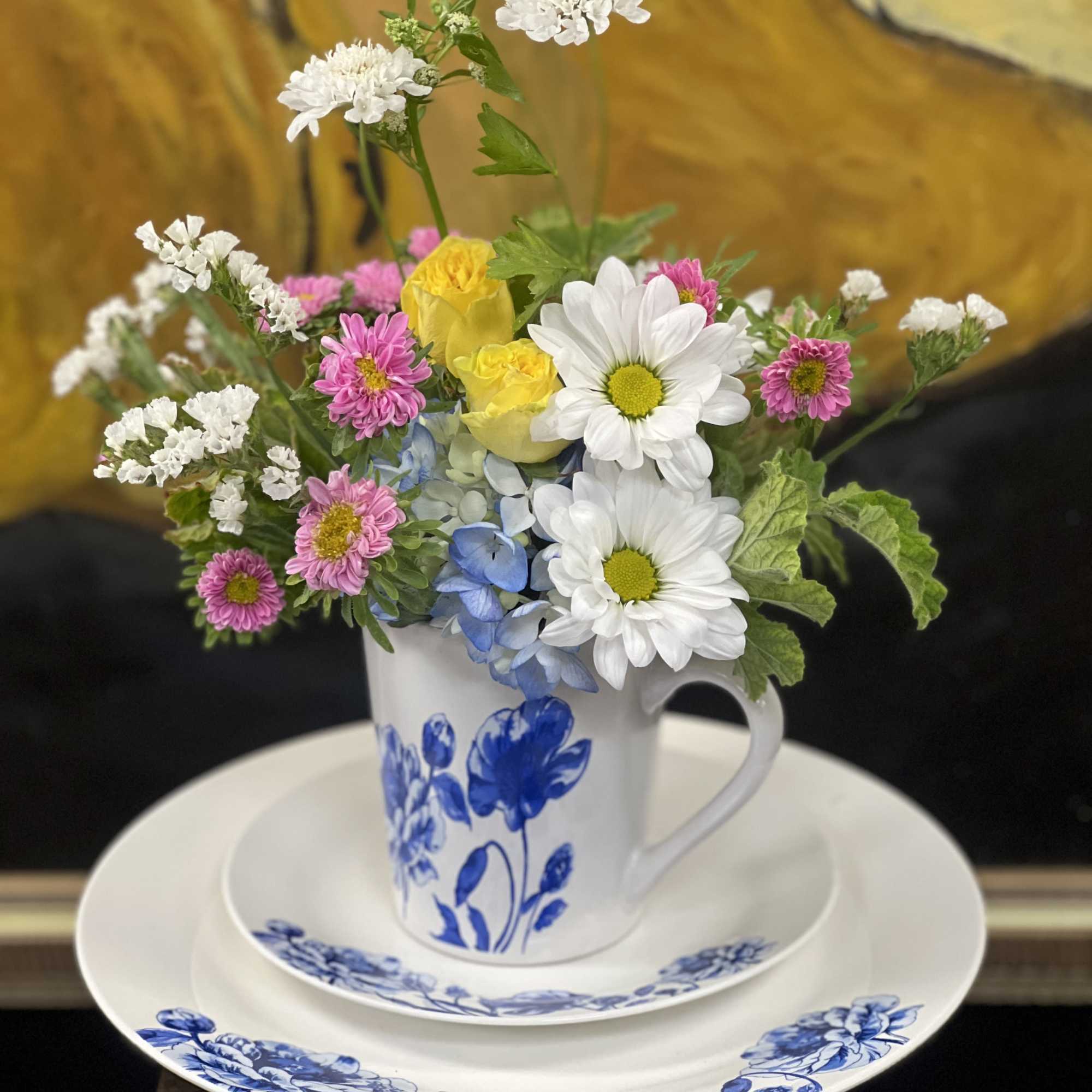 Mixed bouquet in a blue-and-white mug on a matching plate