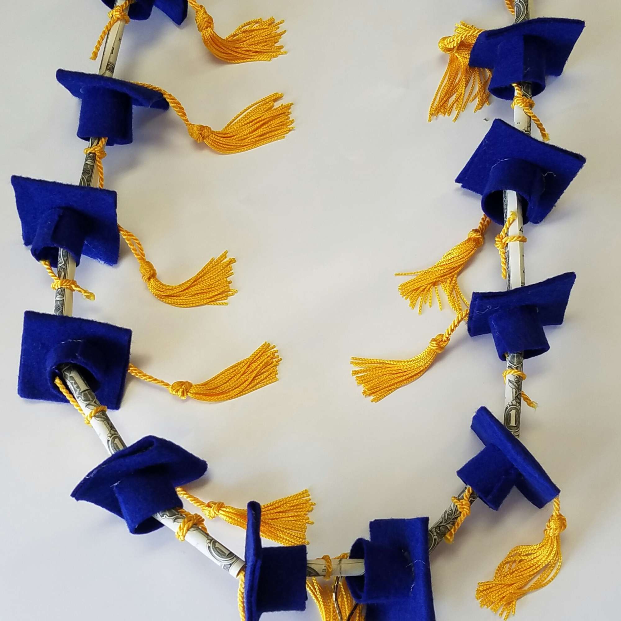 Blue and gold graduation lei made from folded bills and tassels