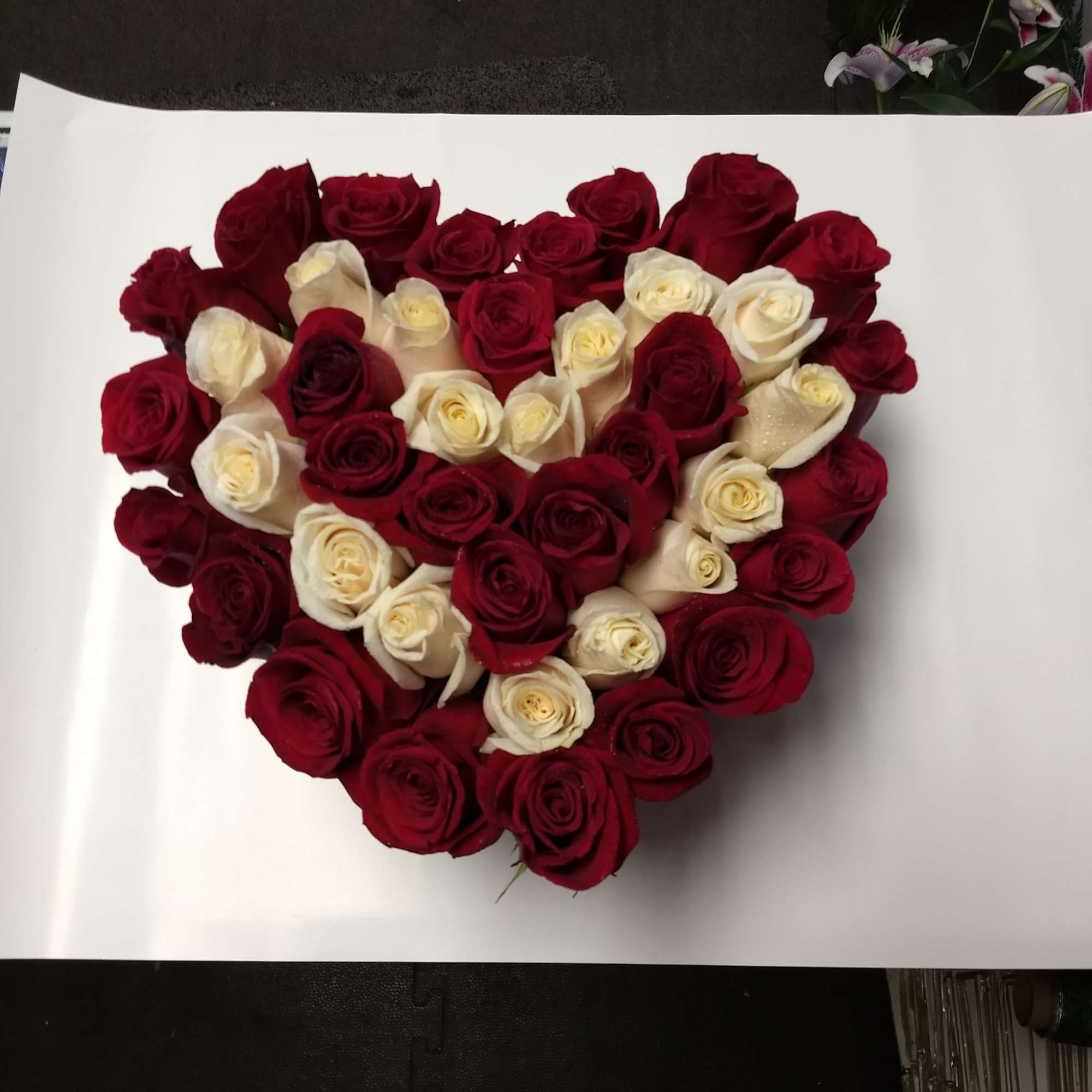 Heart-shaped bouquet of red and white roses