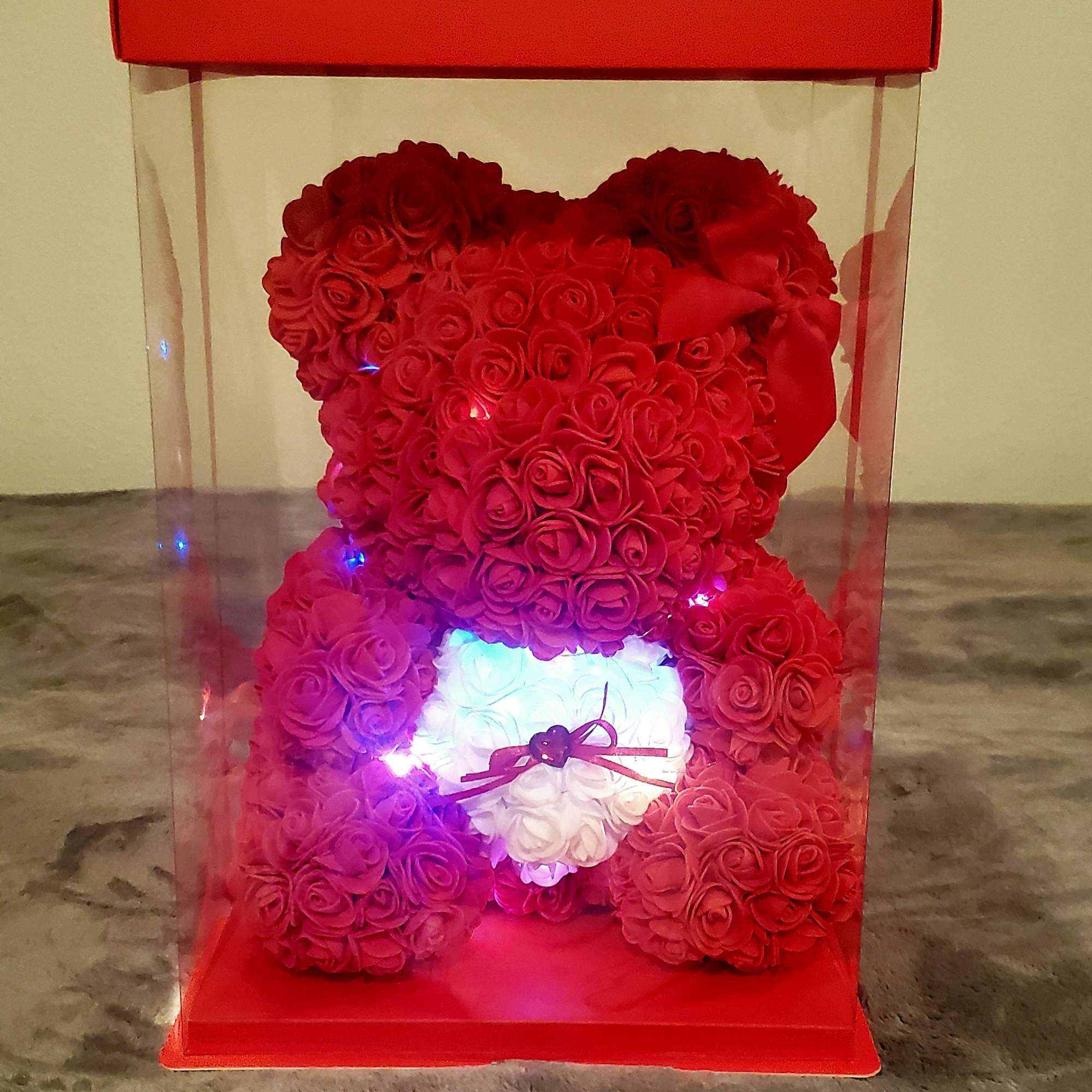 Red rose teddy bear in a clear gift box with a ribbon