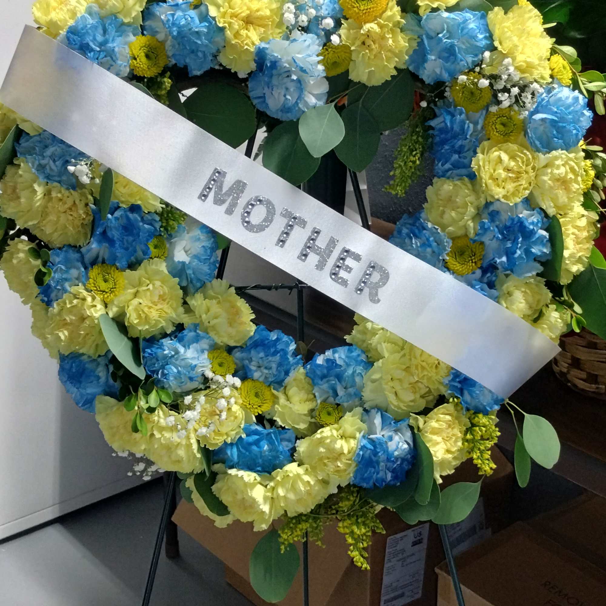 Heart-shaped floral wreath with a silver Mother ribbon