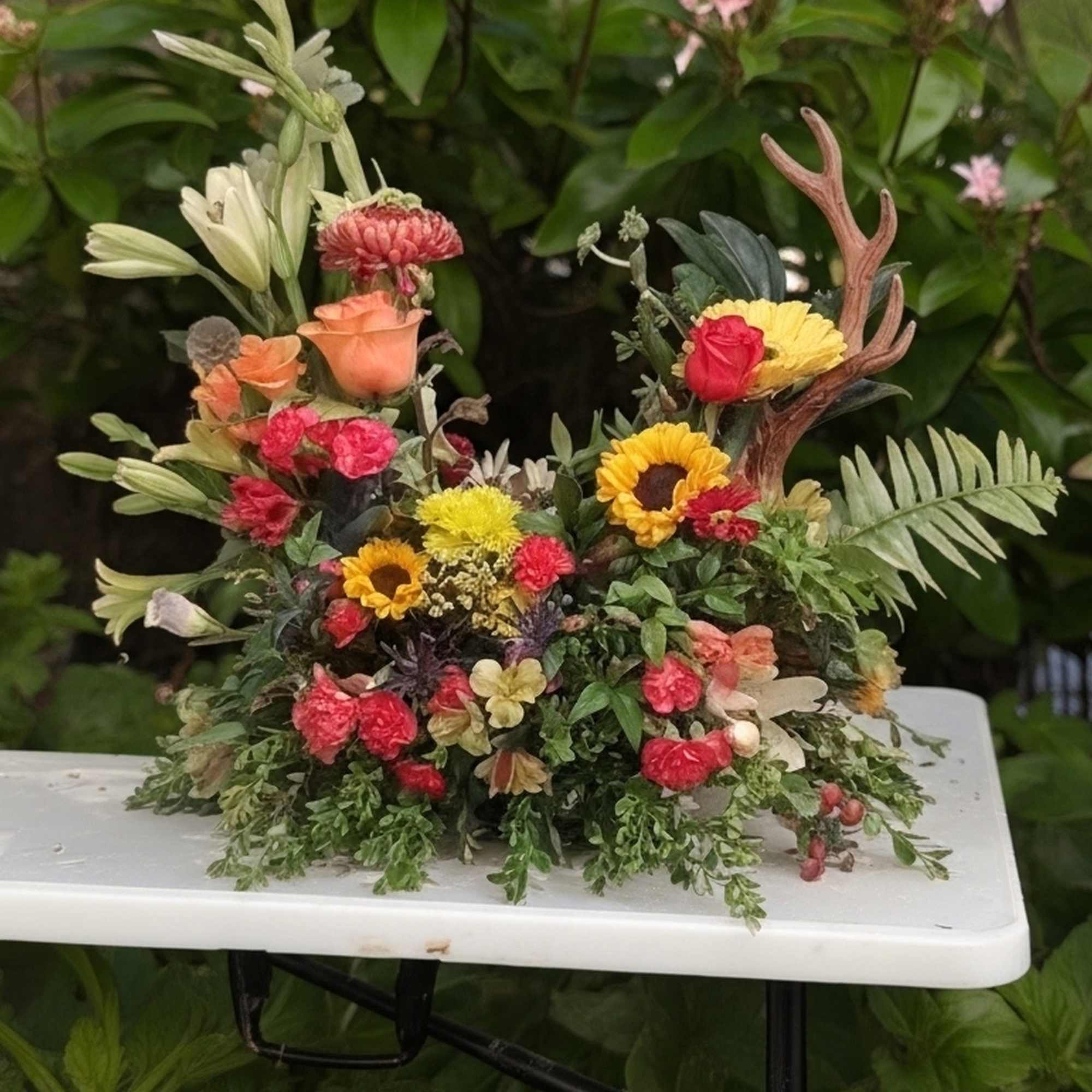 Colorful floral arrangement with roses and daisies on a white table