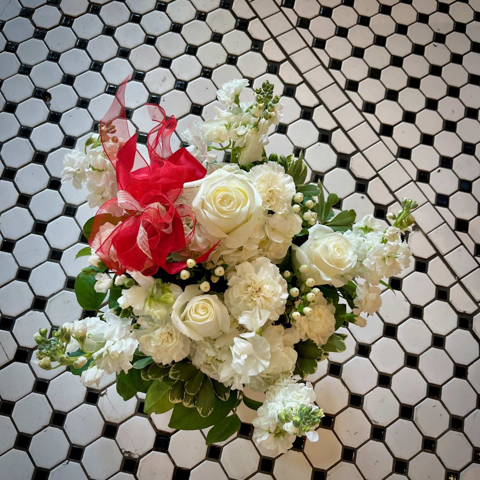 White rose bouquet with carnations and a red ribbon
