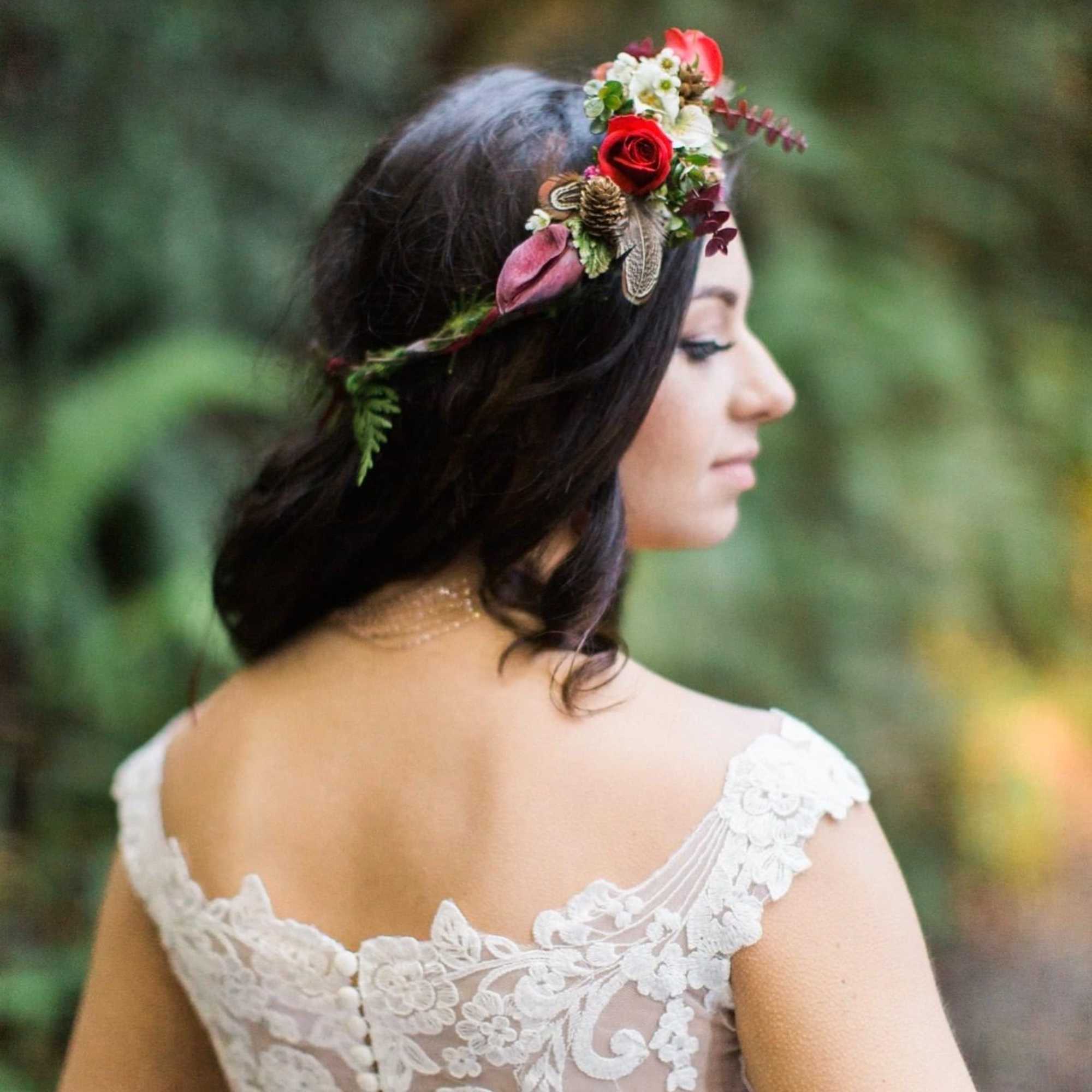 Woman wearing a floral crown with red roses and small white flowers