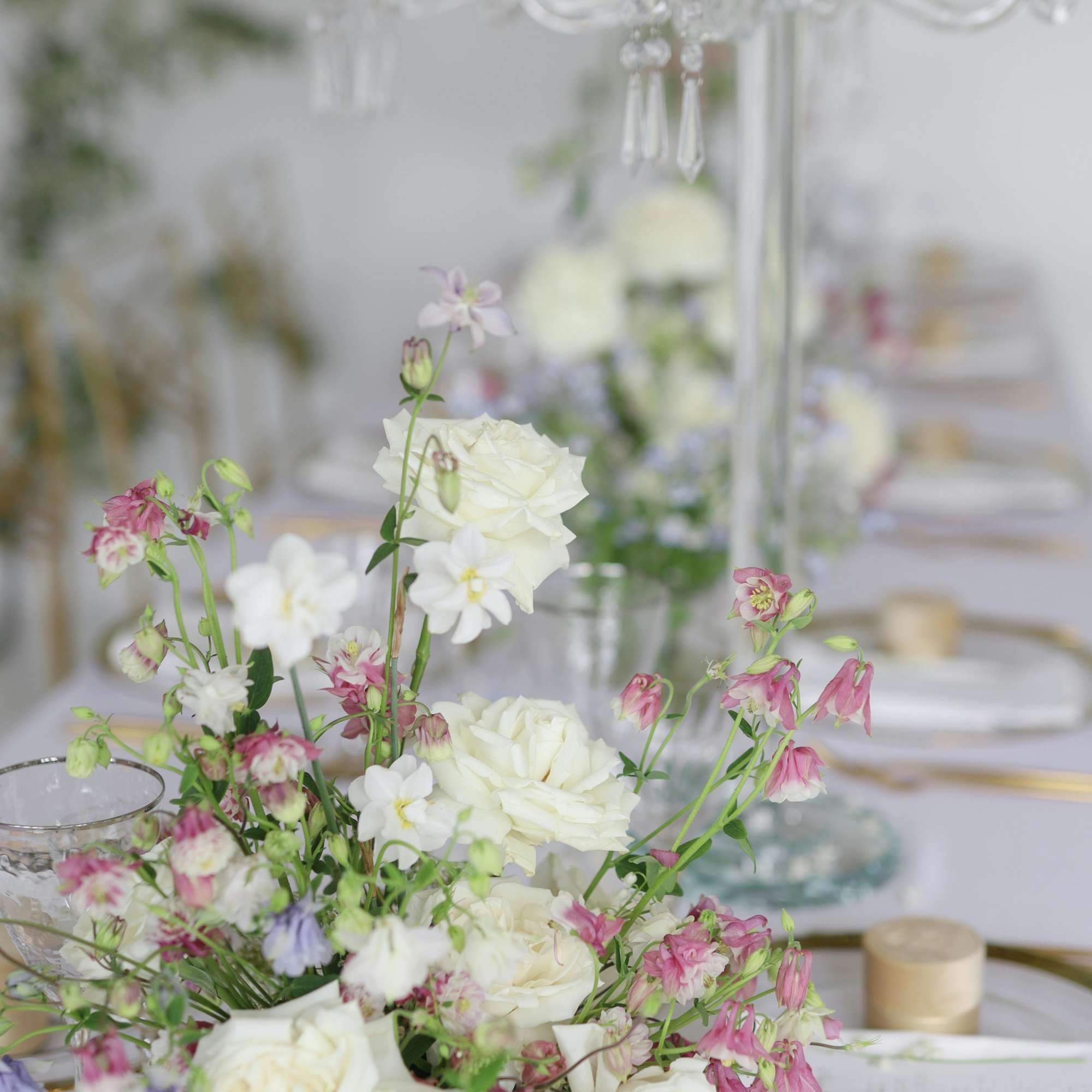 White and pink floral centerpiece on a set table