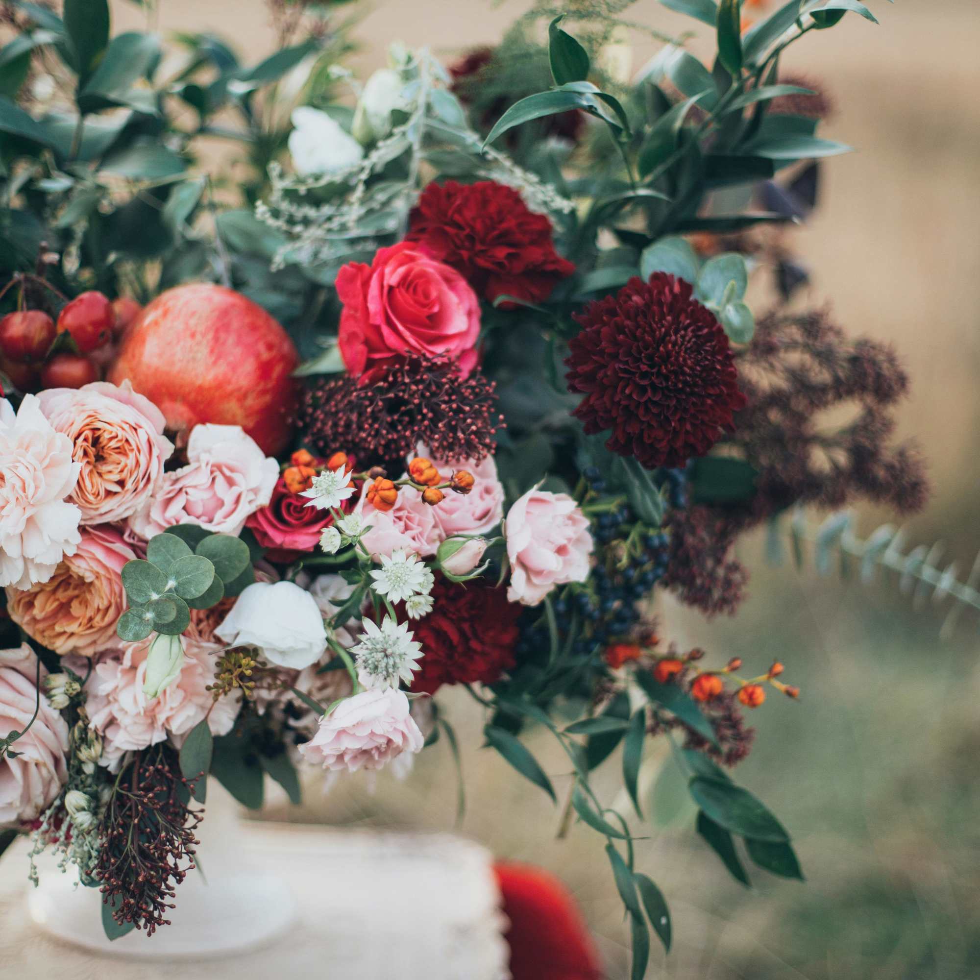 Large floral arrangement with pink, red, and white blooms in a white vase