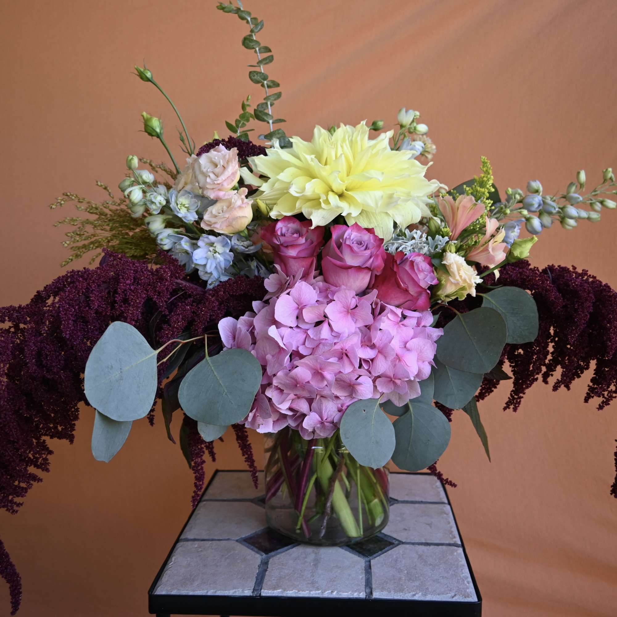 Mixed bouquet in a glass vase with pink, yellow, and purple flowers