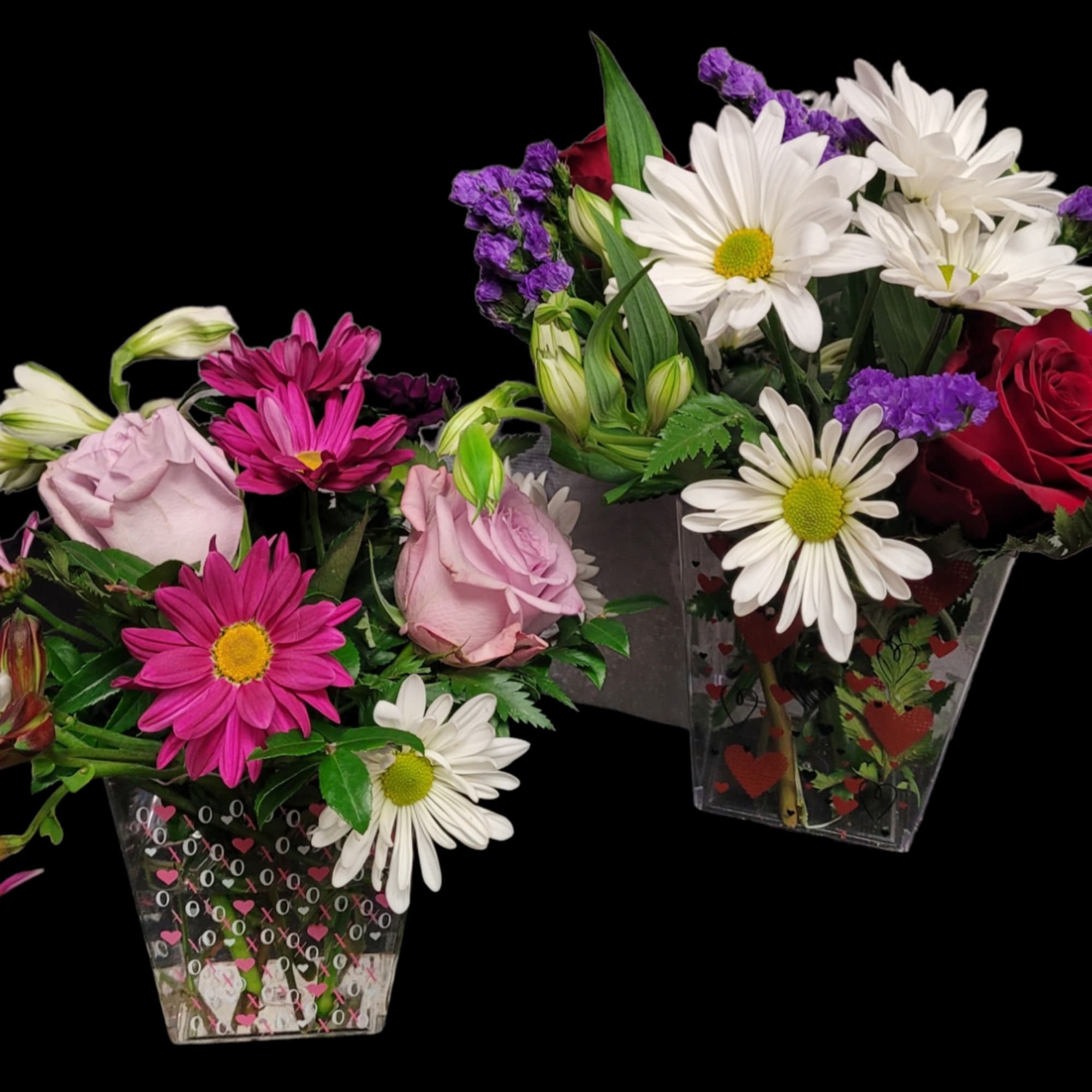 Two mixed flower arrangements in clear heart-patterned vases