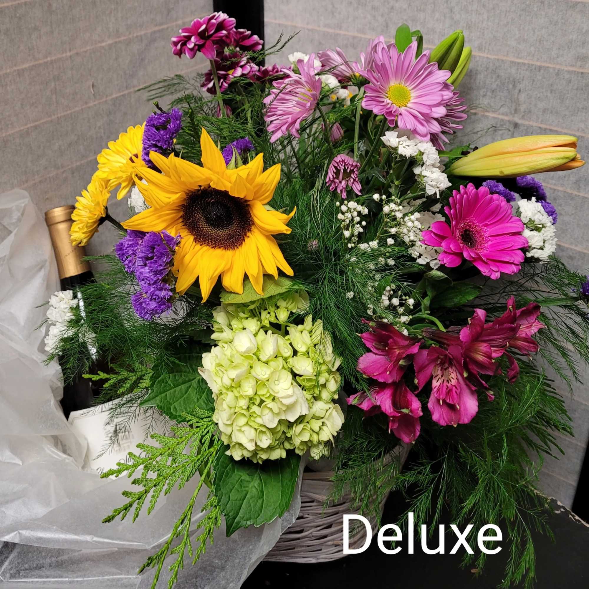 Mixed bouquet with sunflowers, lilies, daisies, and hydrangea in a basket
