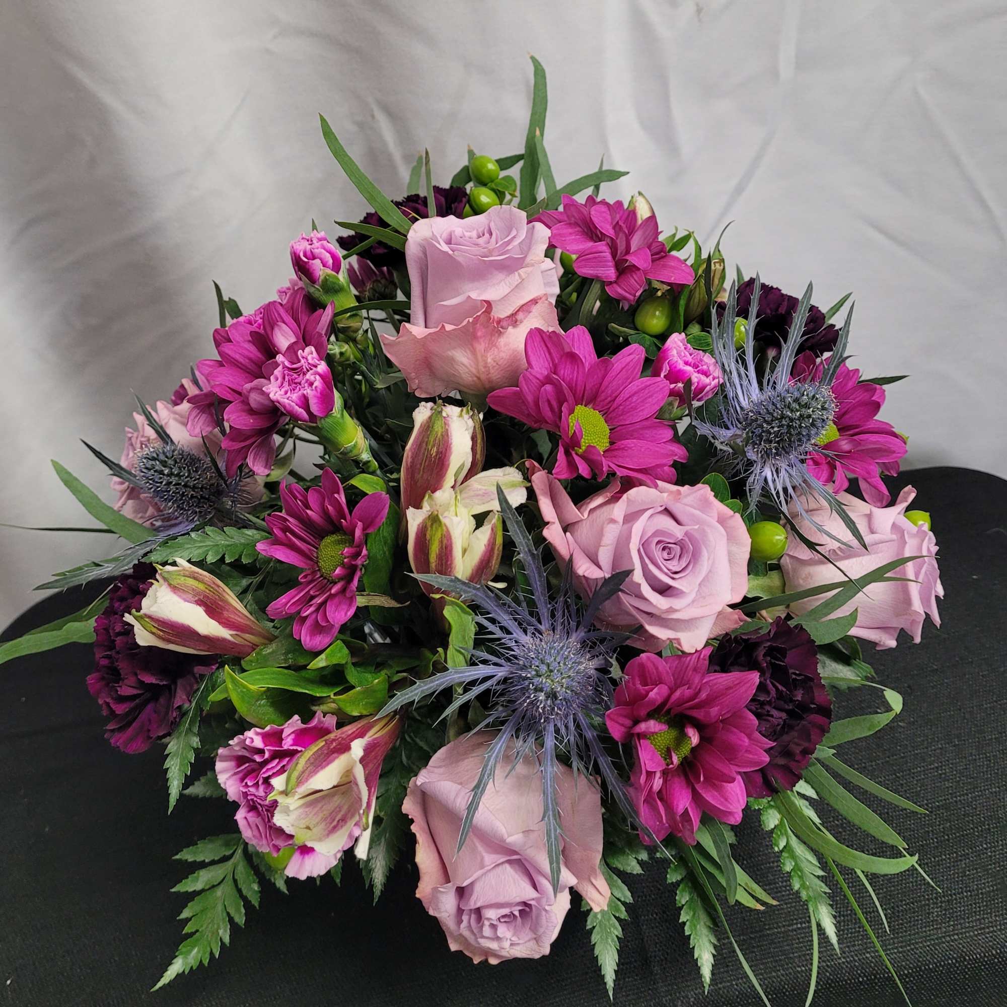 Delightful mixture of roses, carnations, daisies, and berries arranged in a 4x4