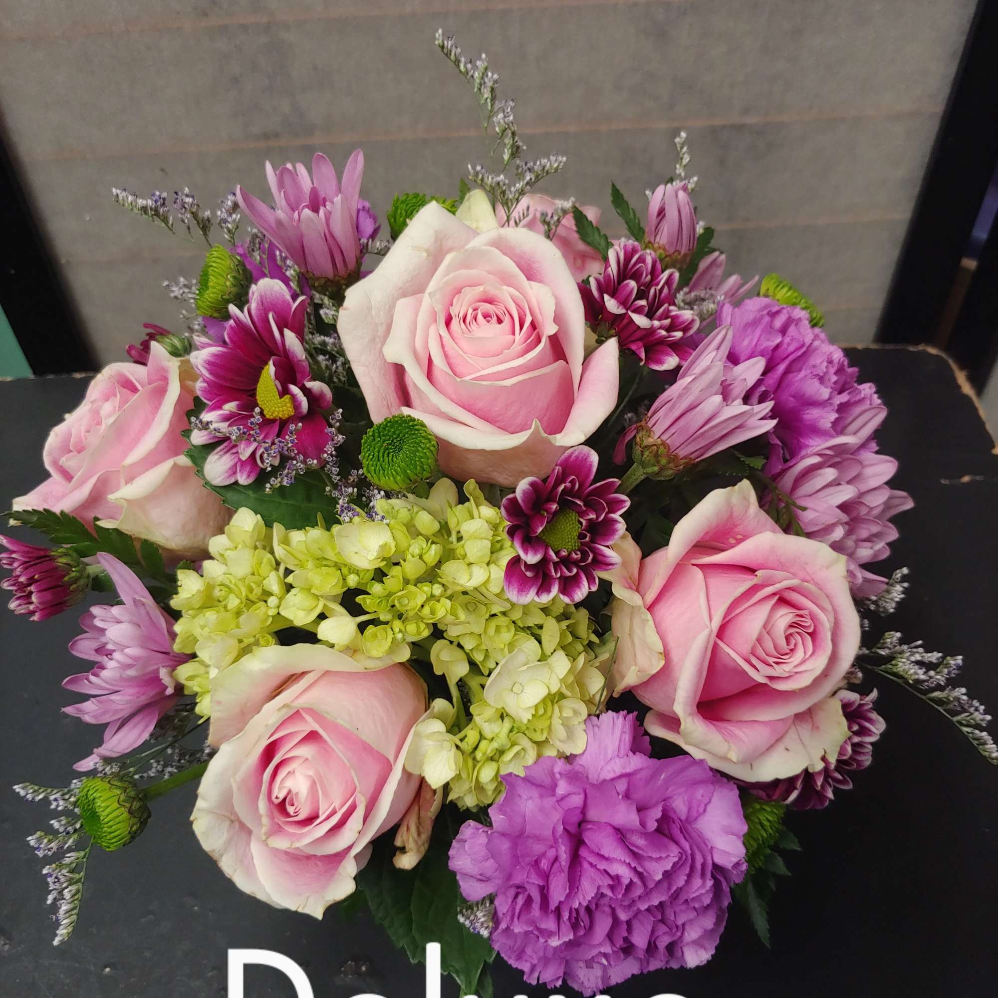 Delightful mixture of roses, carnations, daisies, and berries arranged in a 4x4