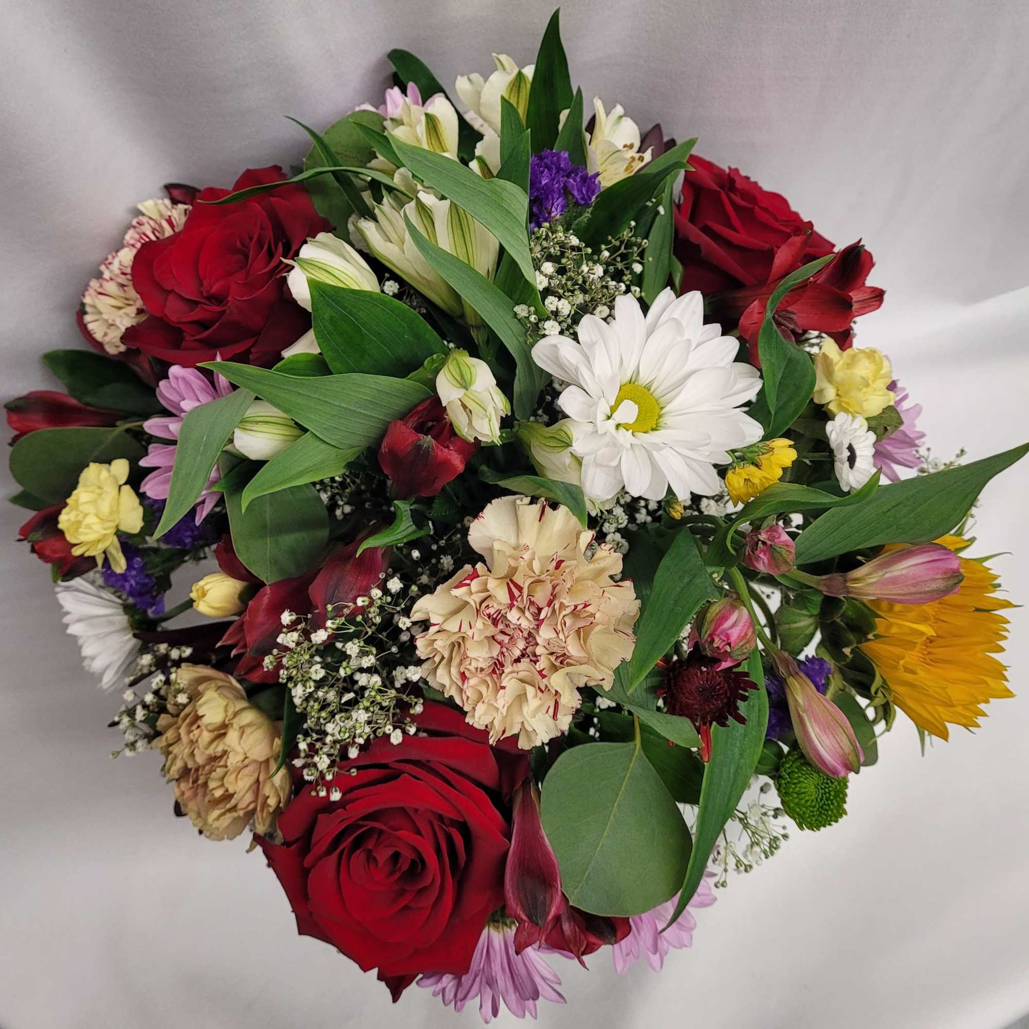 Mixed bouquet with red roses, white daisies, and yellow sunflowers