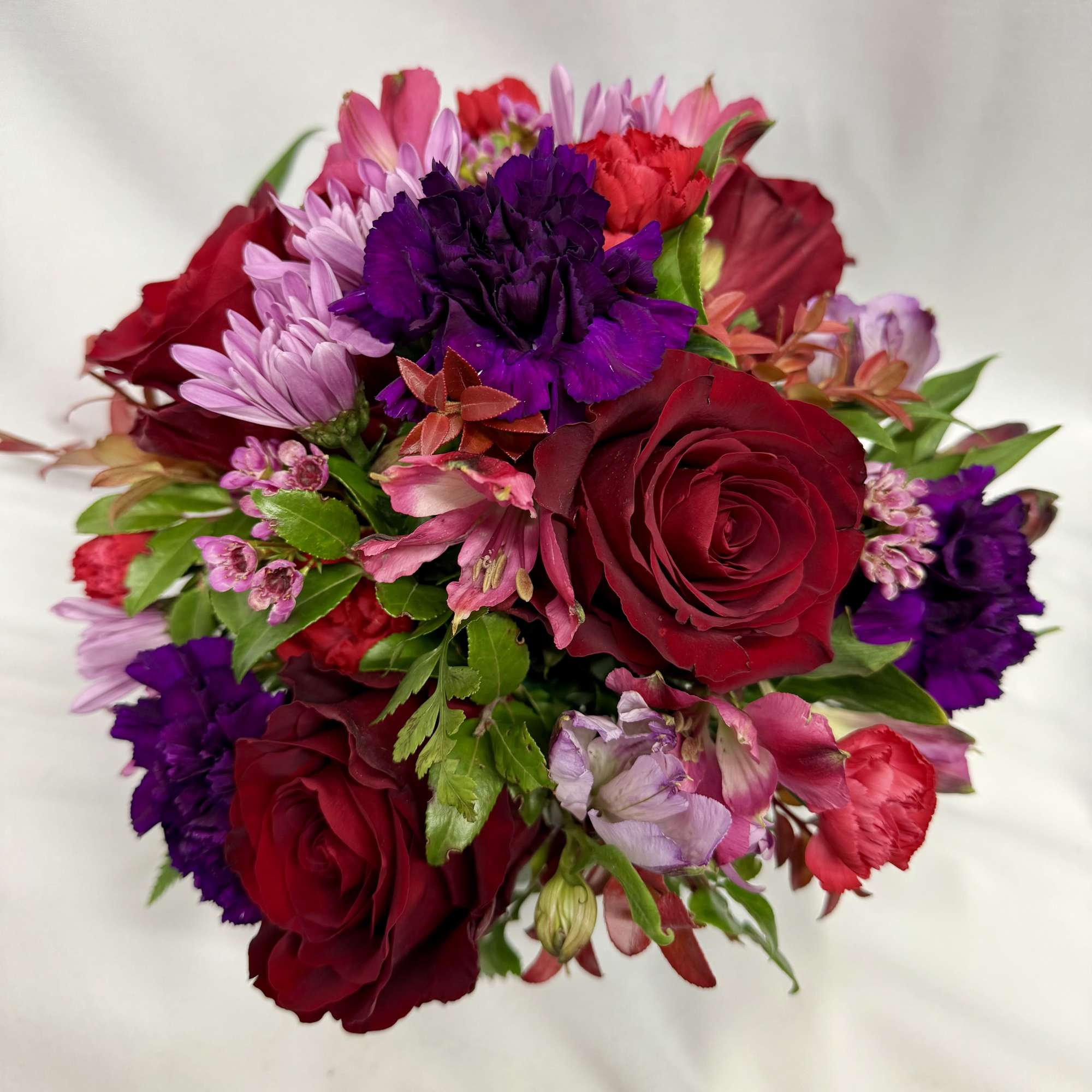 Bouquet of red roses, purple carnations, and pink flowers