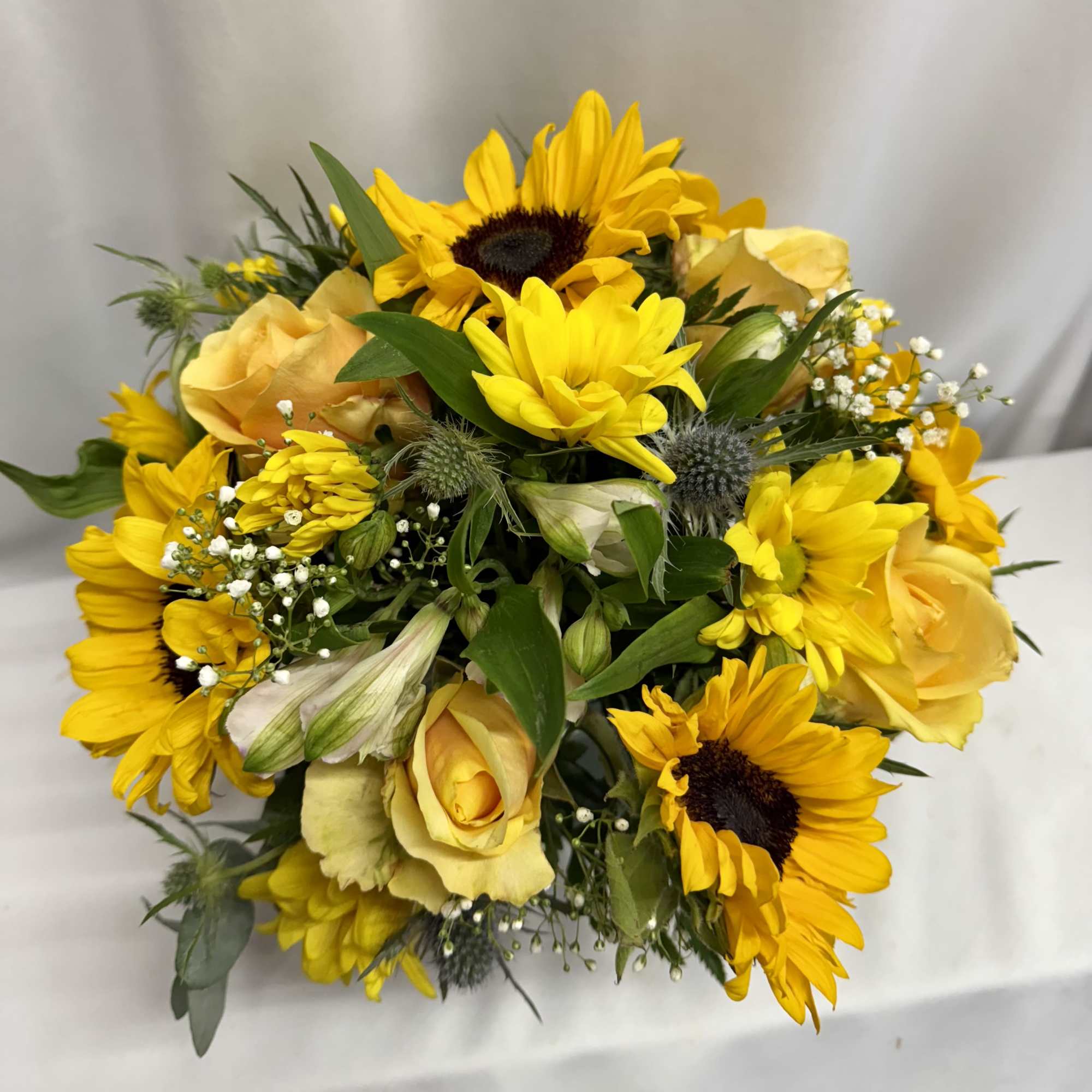Yellow sunflowers and roses in a hand-tied bouquet