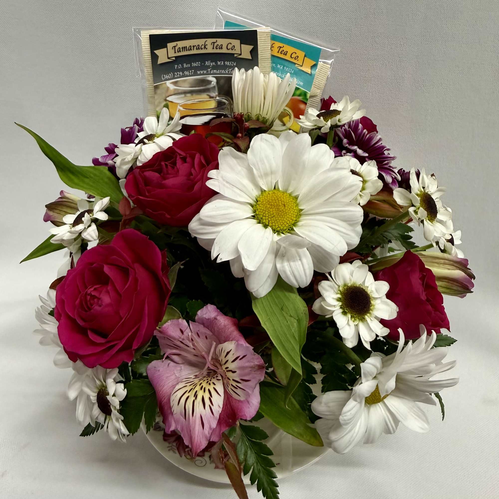 A cozy cluster of mixed roses, daisies, alstroemeria and chrysanthemums arranged in
