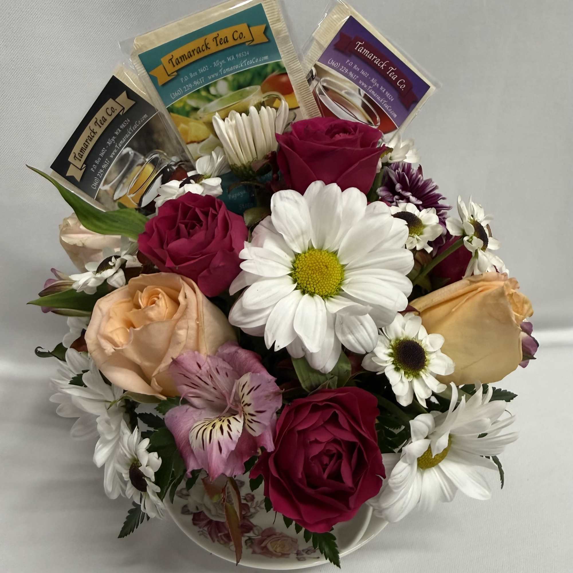 A cozy cluster of mixed roses, daisies, alstroemeria and chrysanthemums arranged in