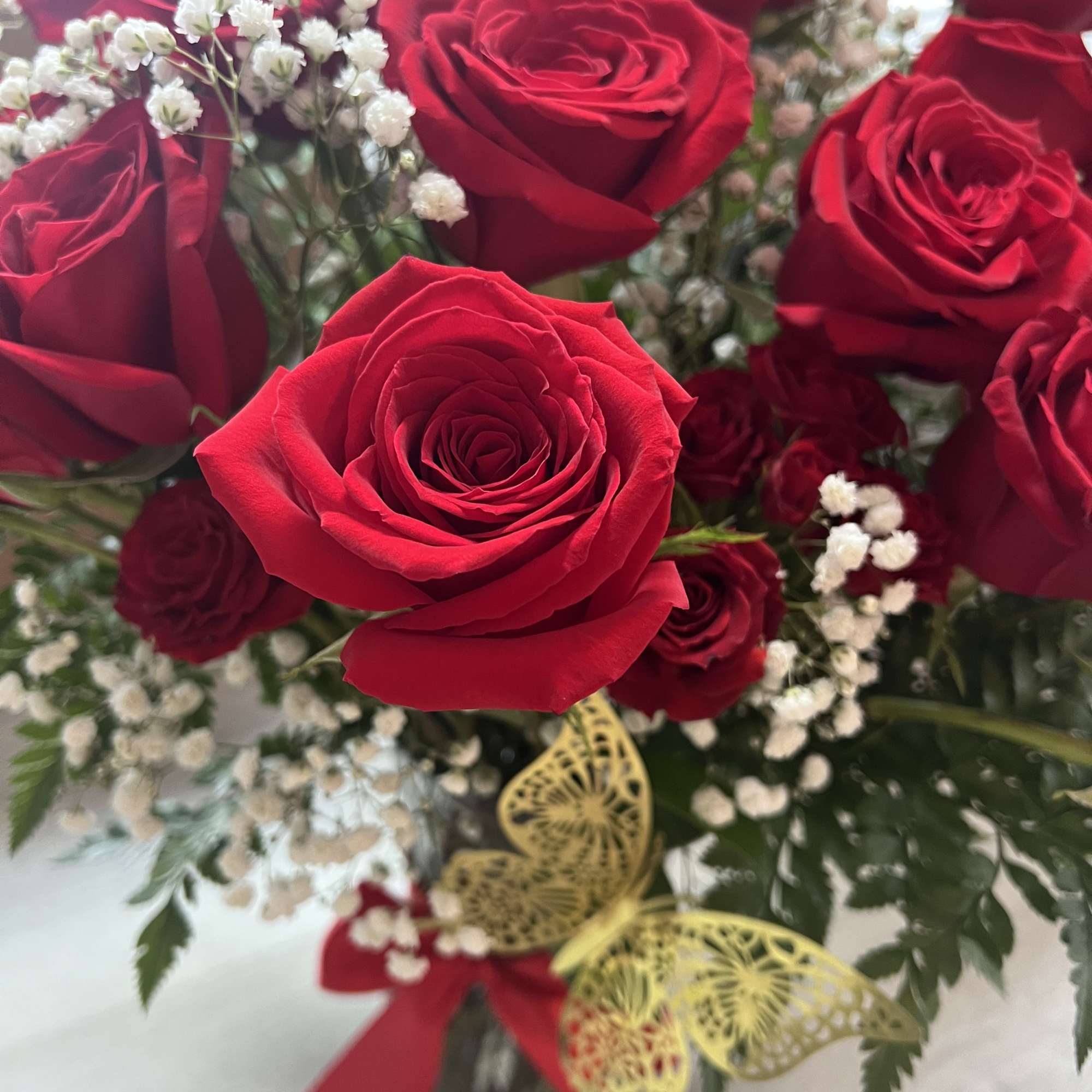 Bouquet of red roses with white baby's breath in a glass vase