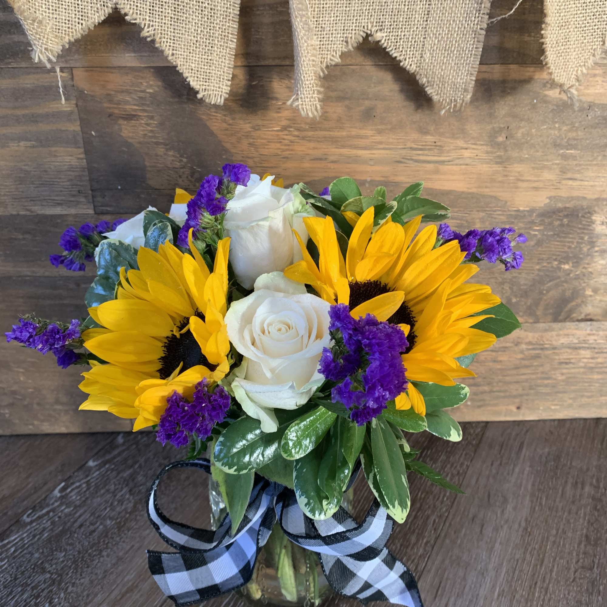 Mason jar filled with sunflowers and roses