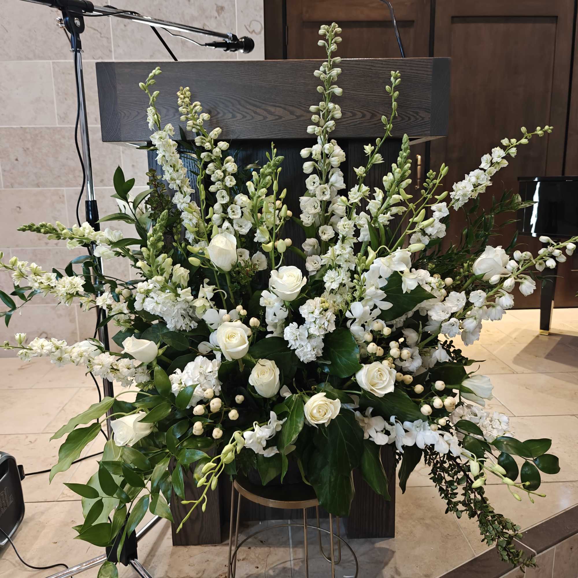 Pure white flowers and lush foliage in a paper mache pot. This