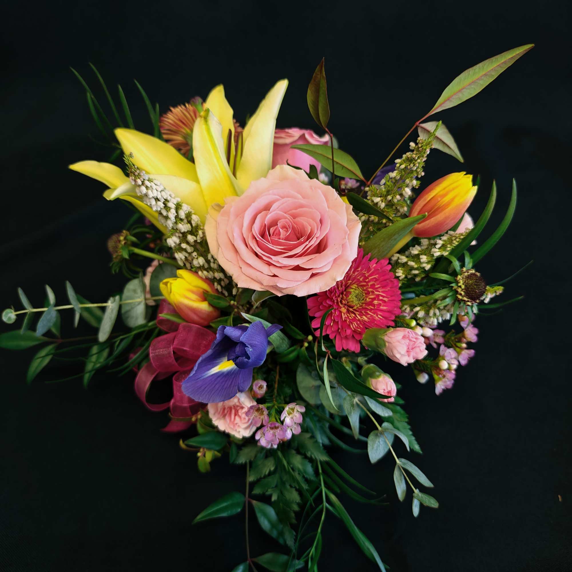 Mixed bouquet with a pink rose, yellow lilies, and a purple iris