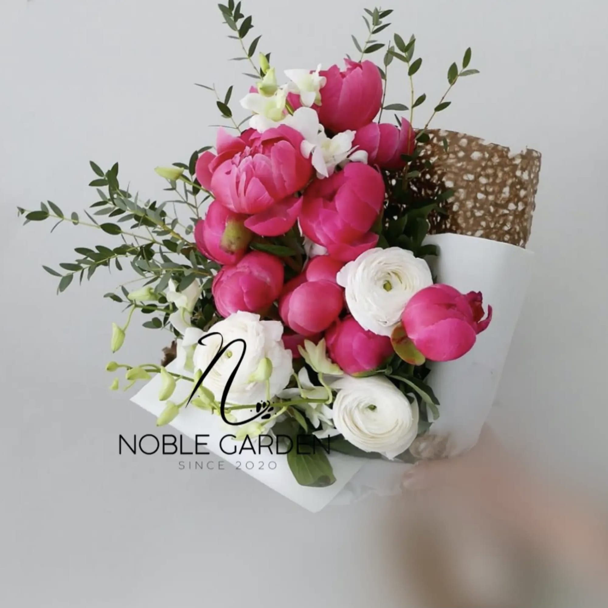 Bouquet of pink and white flowers wrapped in white paper