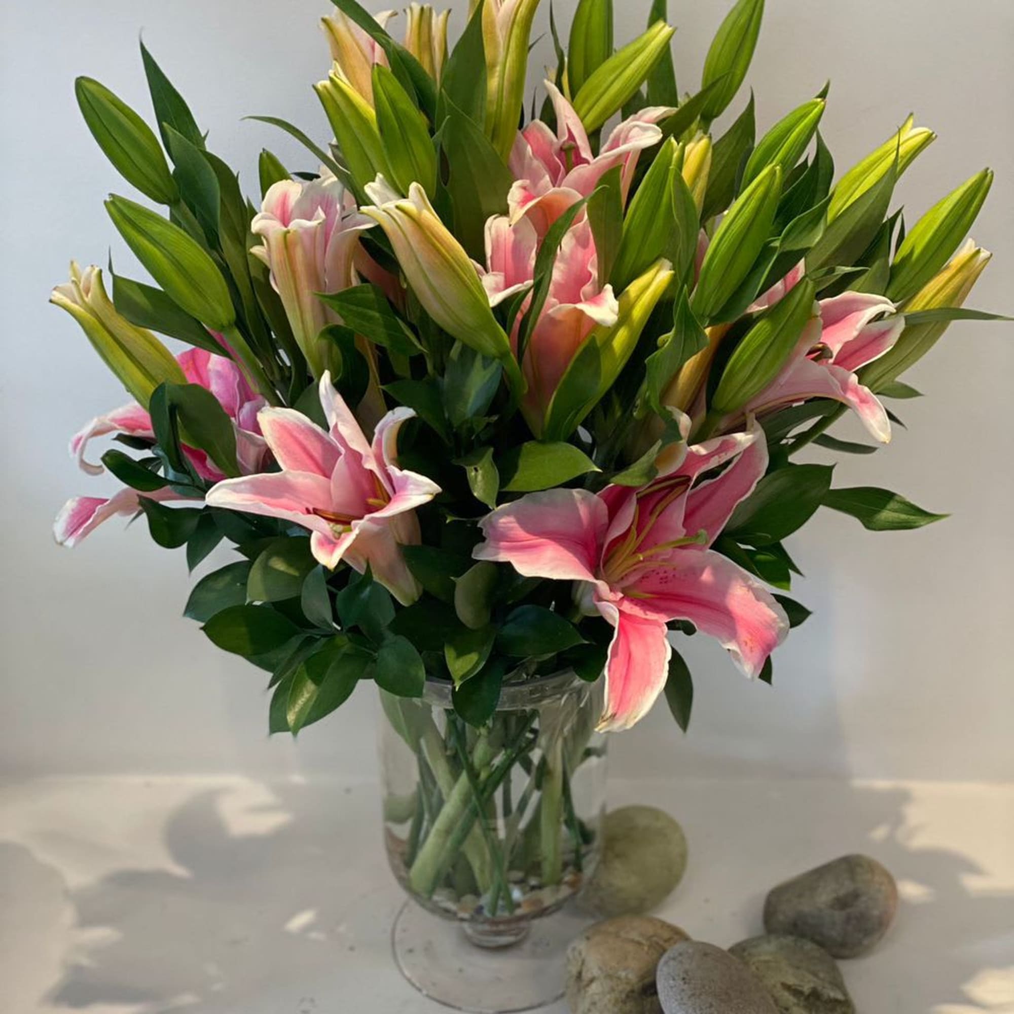 Pink lilies arranged in a clear glass vase