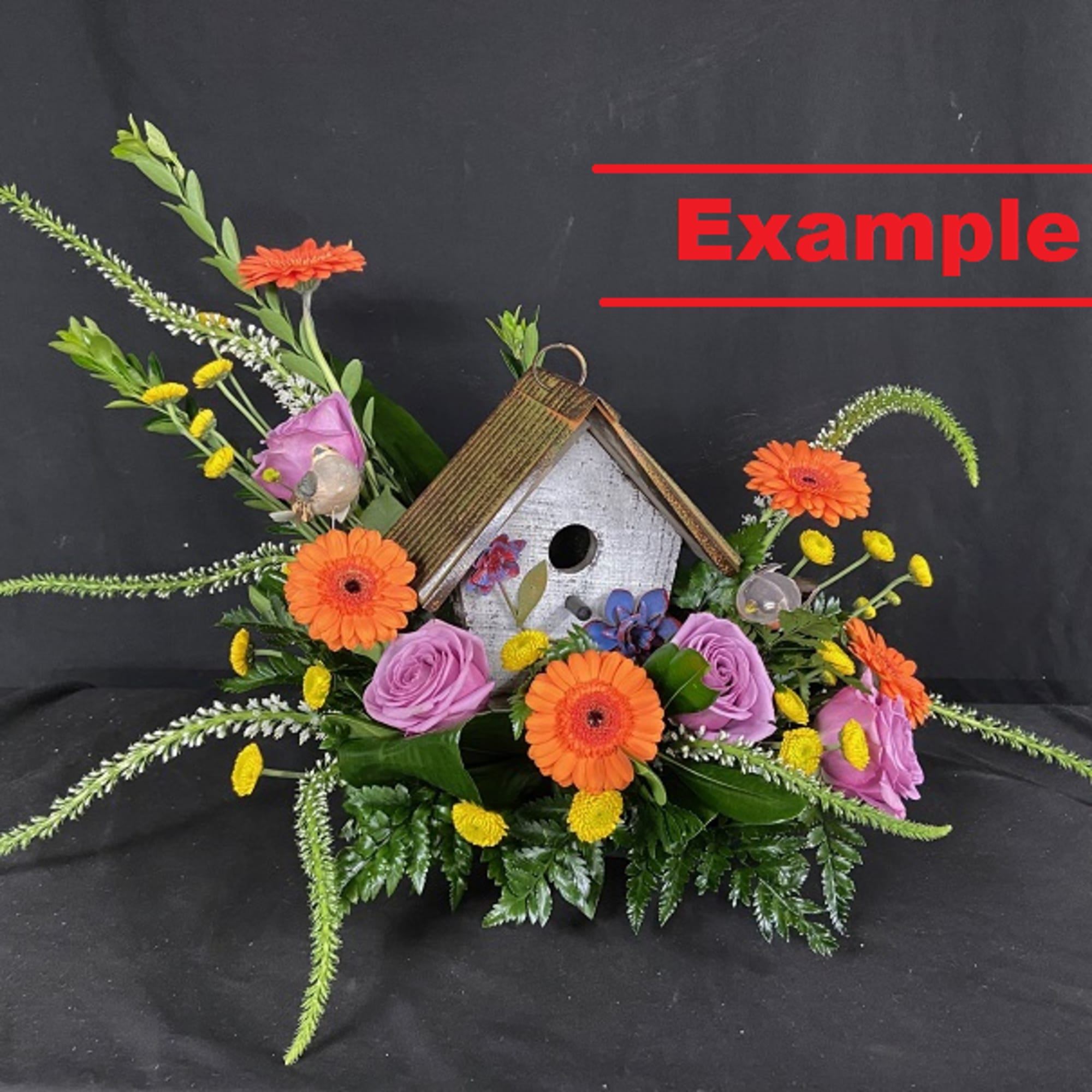 Birdhouse centerpiece with orange and purple flowers