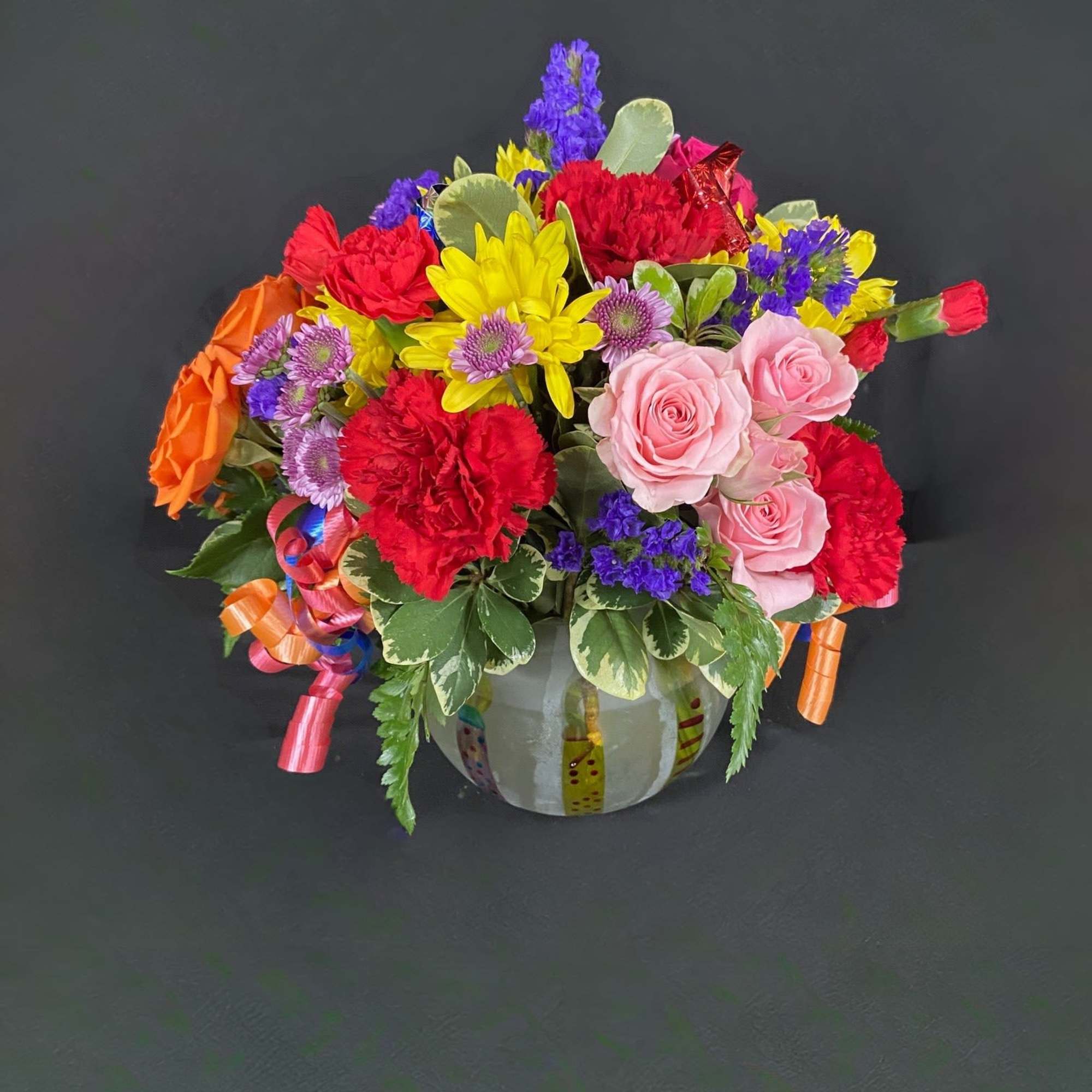 A frosted globe is decorated with birthday candles and filled with seasonal