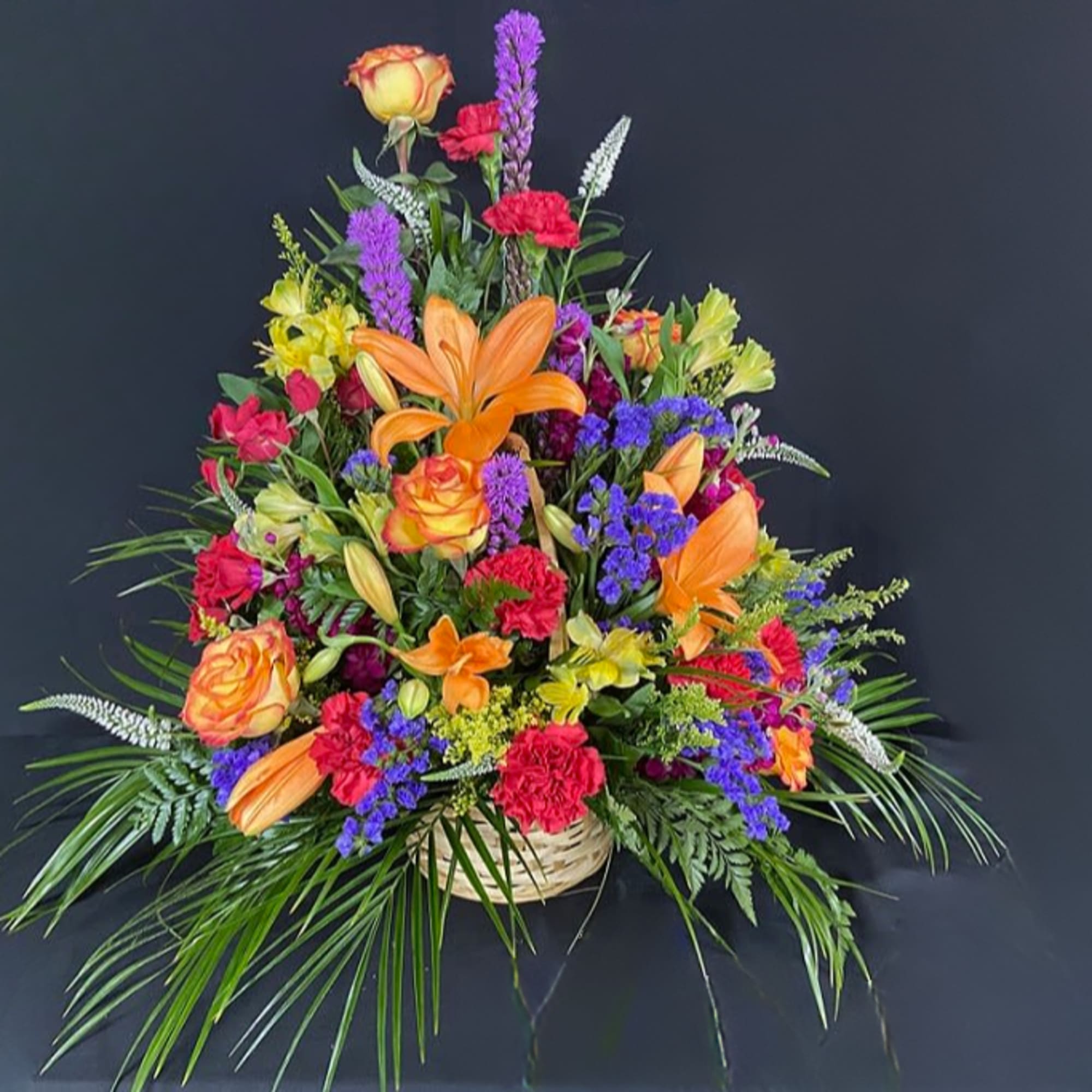 Colorful mixed flower arrangement in a woven basket