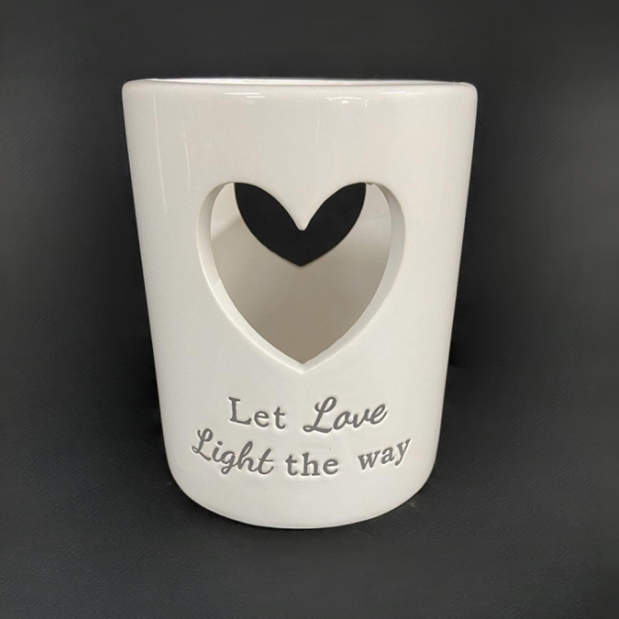 White ceramic candle holder with a heart cutout and "Let Love Light the way" text