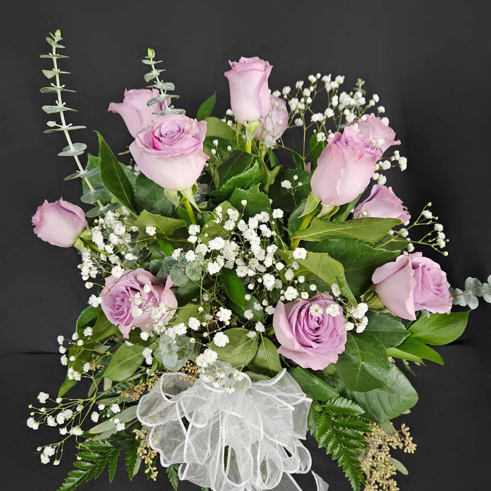 Lavender rose bouquet with baby's breath and a white ribbon bow