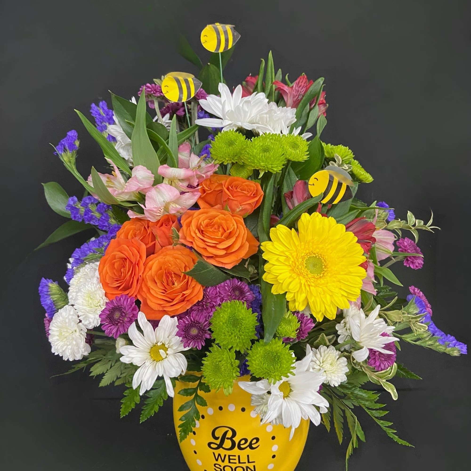 Tiny bees float among a vibrant and beautiful garden of yellow Gerberas