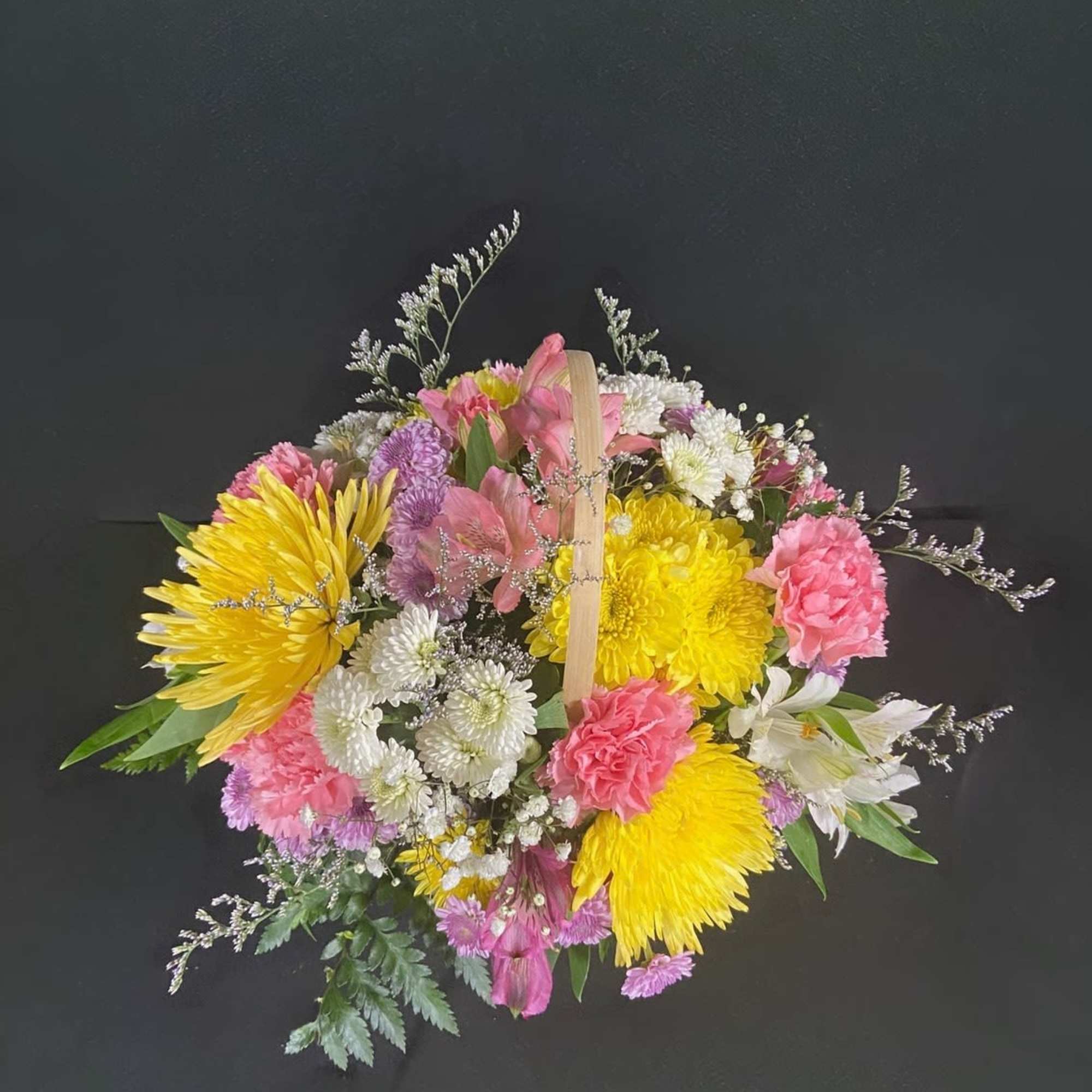 A basket of bright, colorful flowers to pick up anyone's spirits. Includes