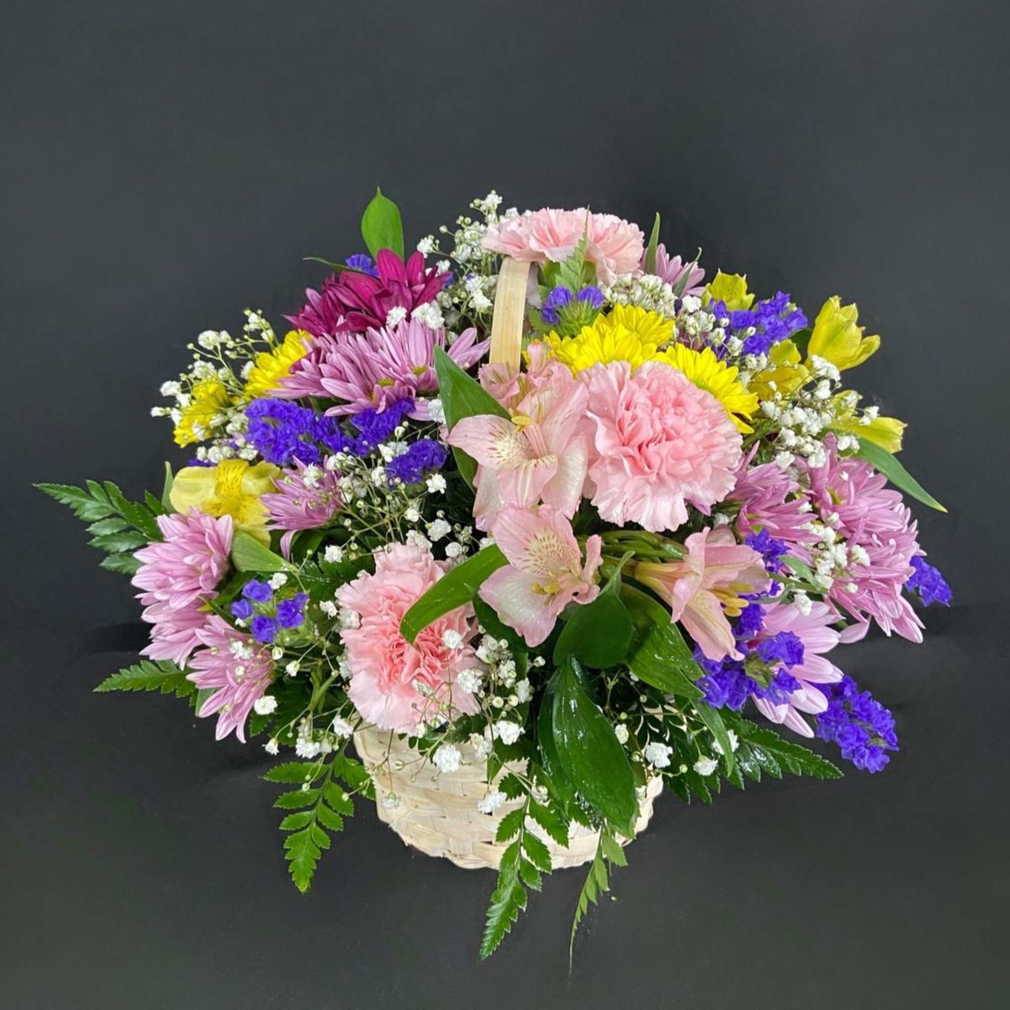 A basket of bright, colorful flowers to pick up anyone's spirits. Includes