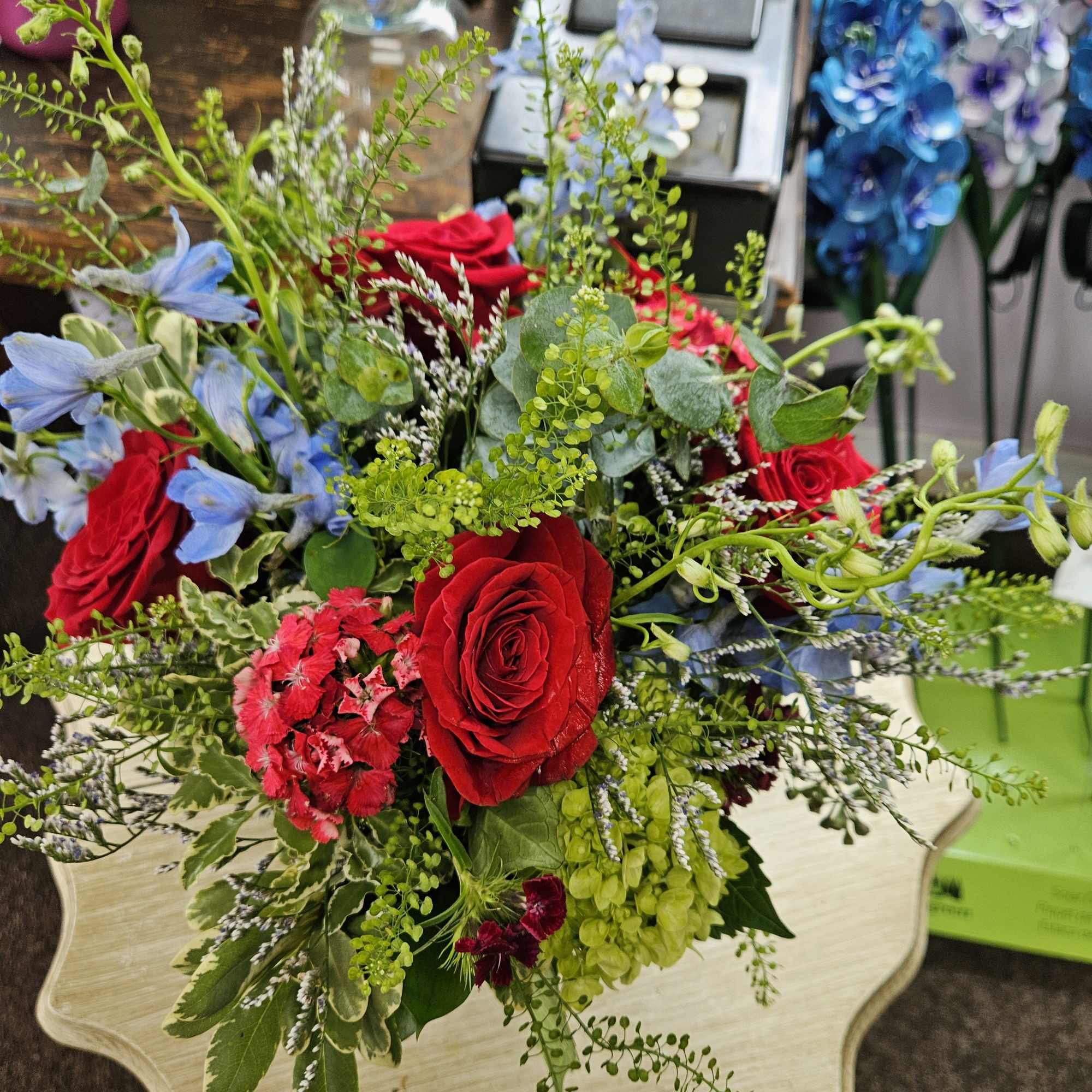 Seasonal mix of summer flowers enhanced with red roses and green hydrangeas!