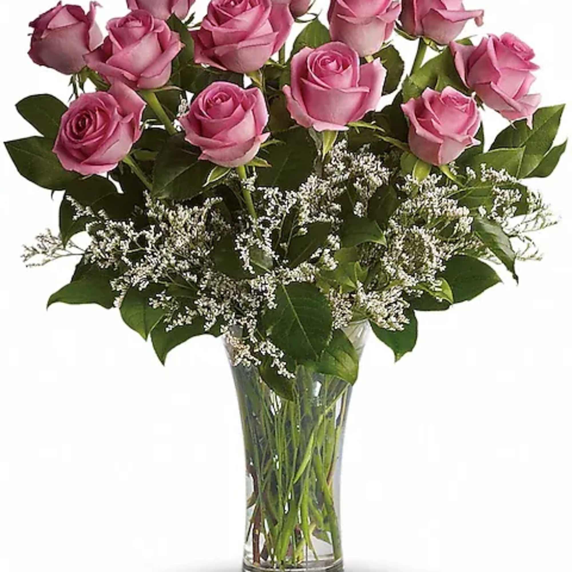 Pink roses arranged in a clear glass vase with white filler flowers