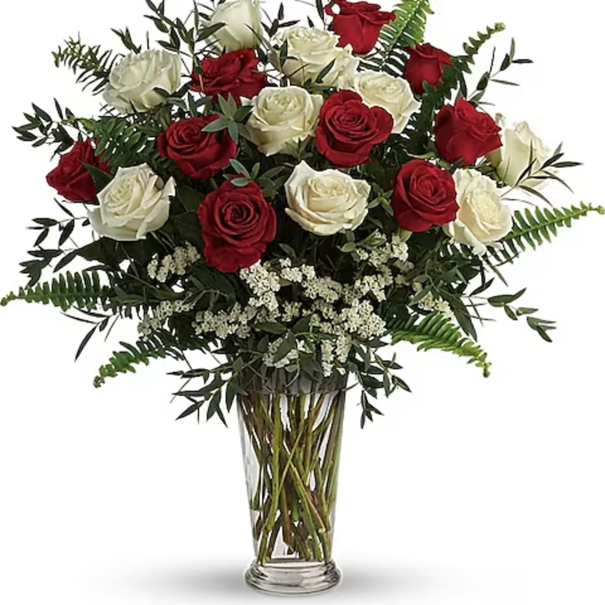 Red and white roses in a clear glass vase