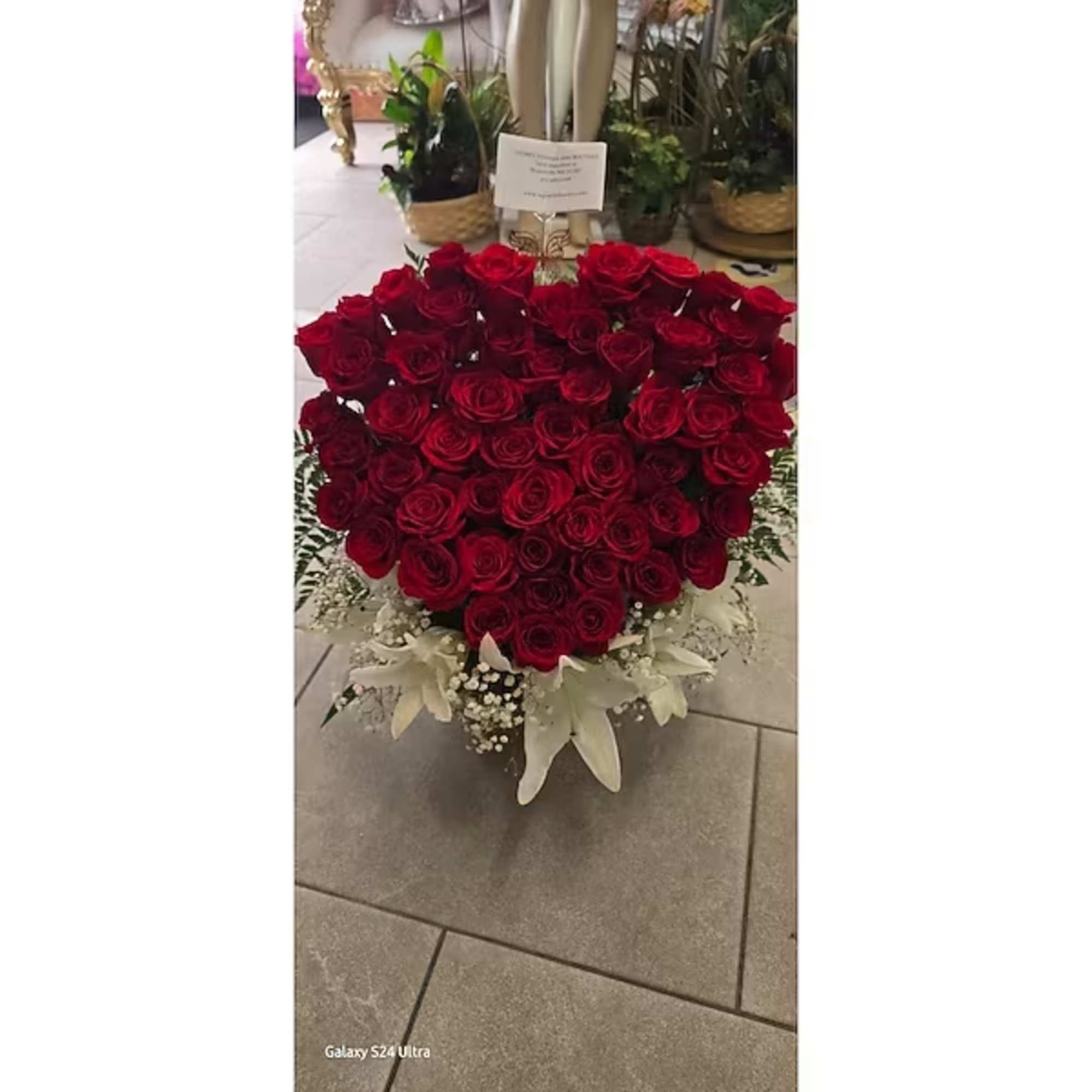 Heart-shaped bouquet of red roses with white lilies at the base