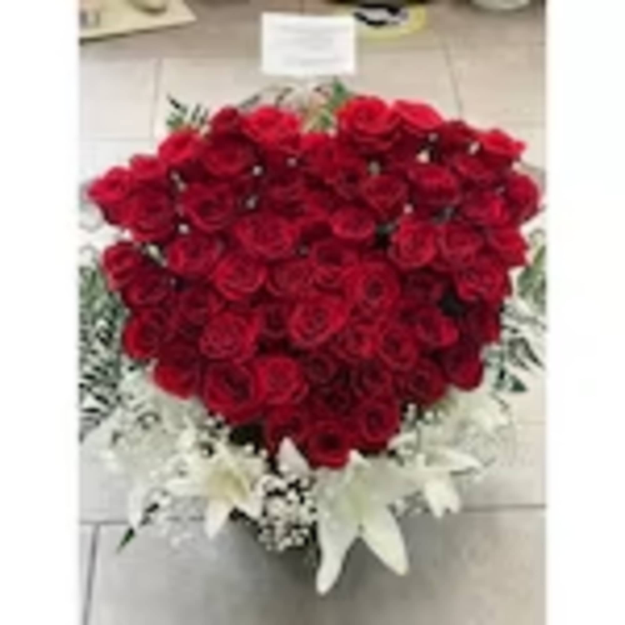 Heart-shaped bouquet of red roses with white accents