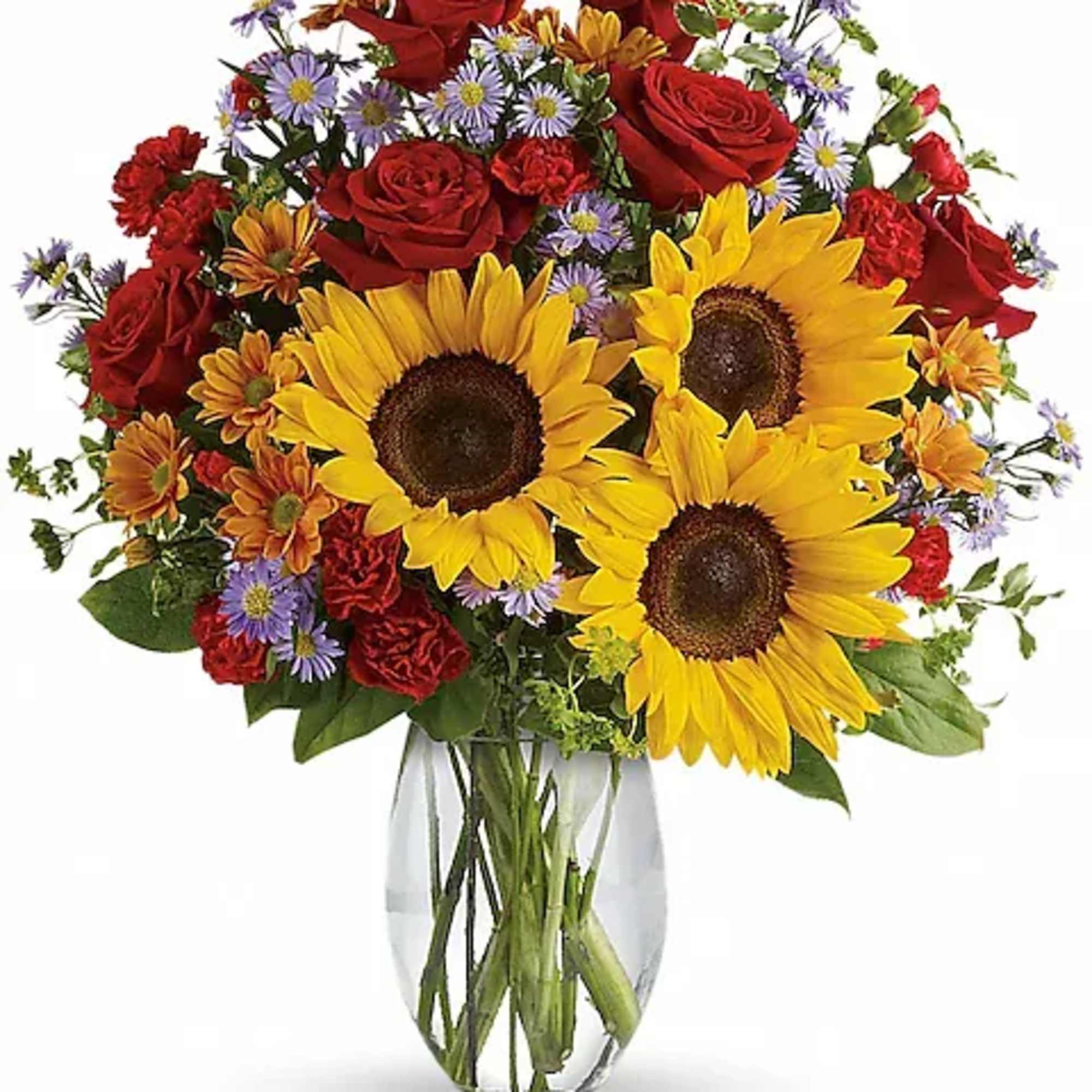Bouquet of sunflowers, red roses, and purple daisies in a clear glass vase