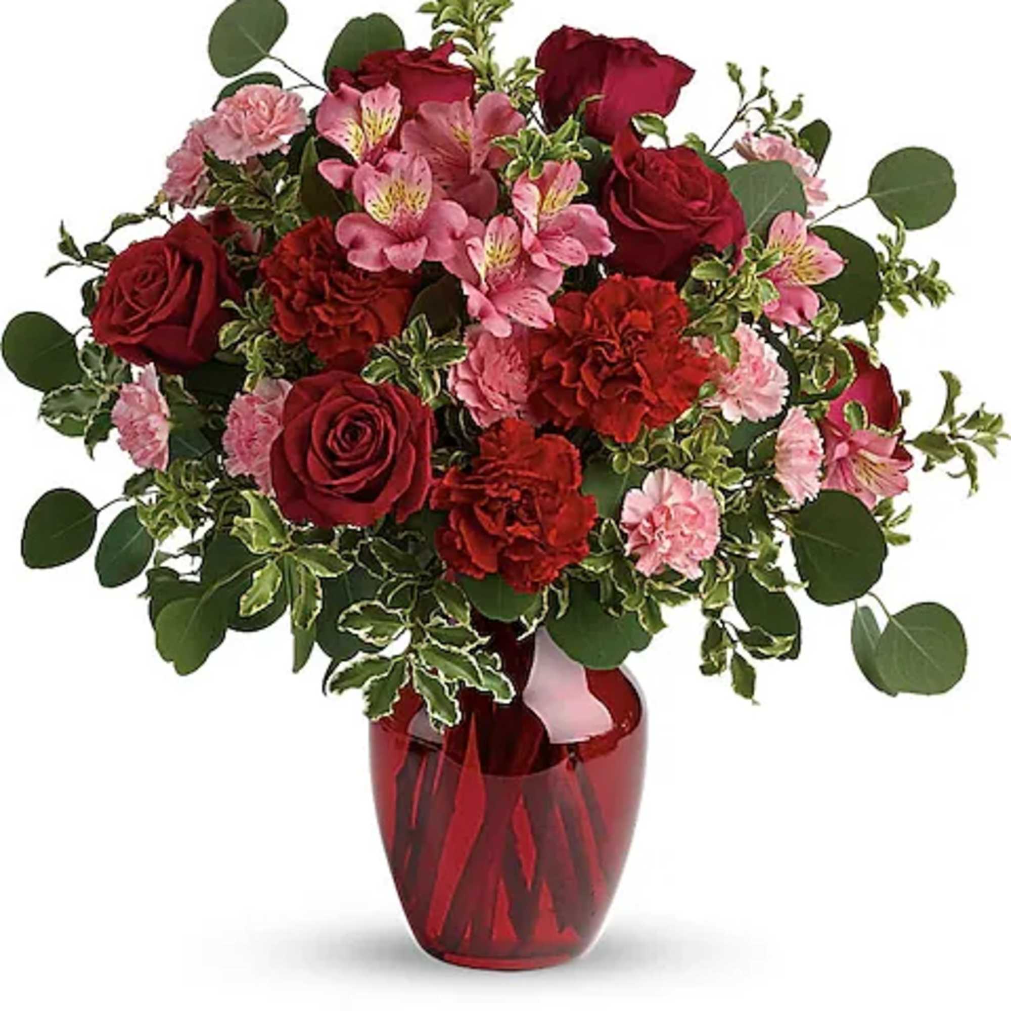 Red roses and pink flowers arranged in a red glass vase