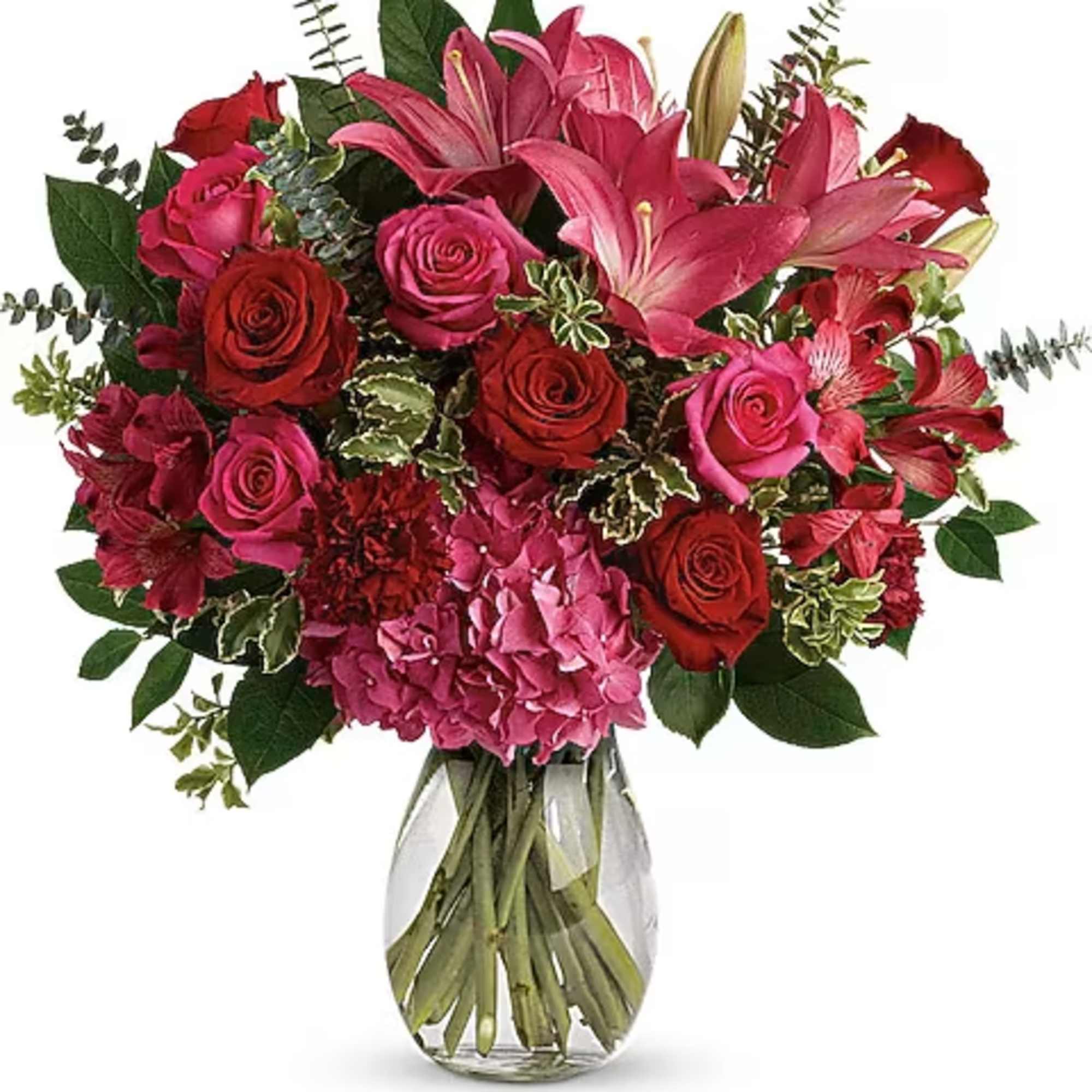 Pink lilies and red roses in a clear glass vase