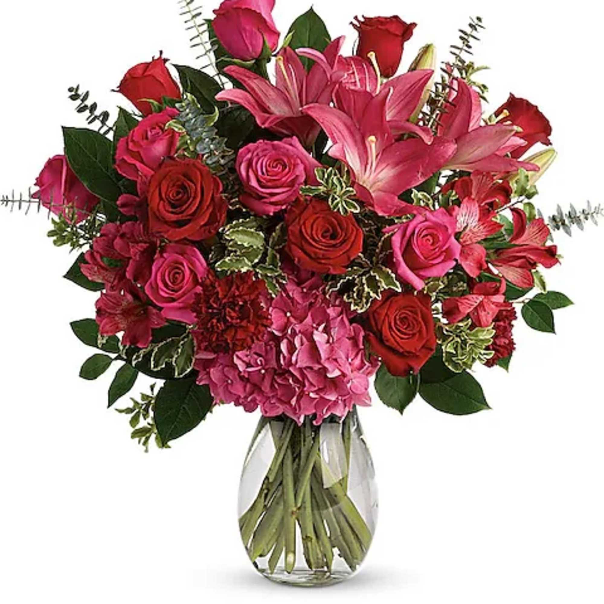 Bouquet of pink and red roses with lilies in a glass vase