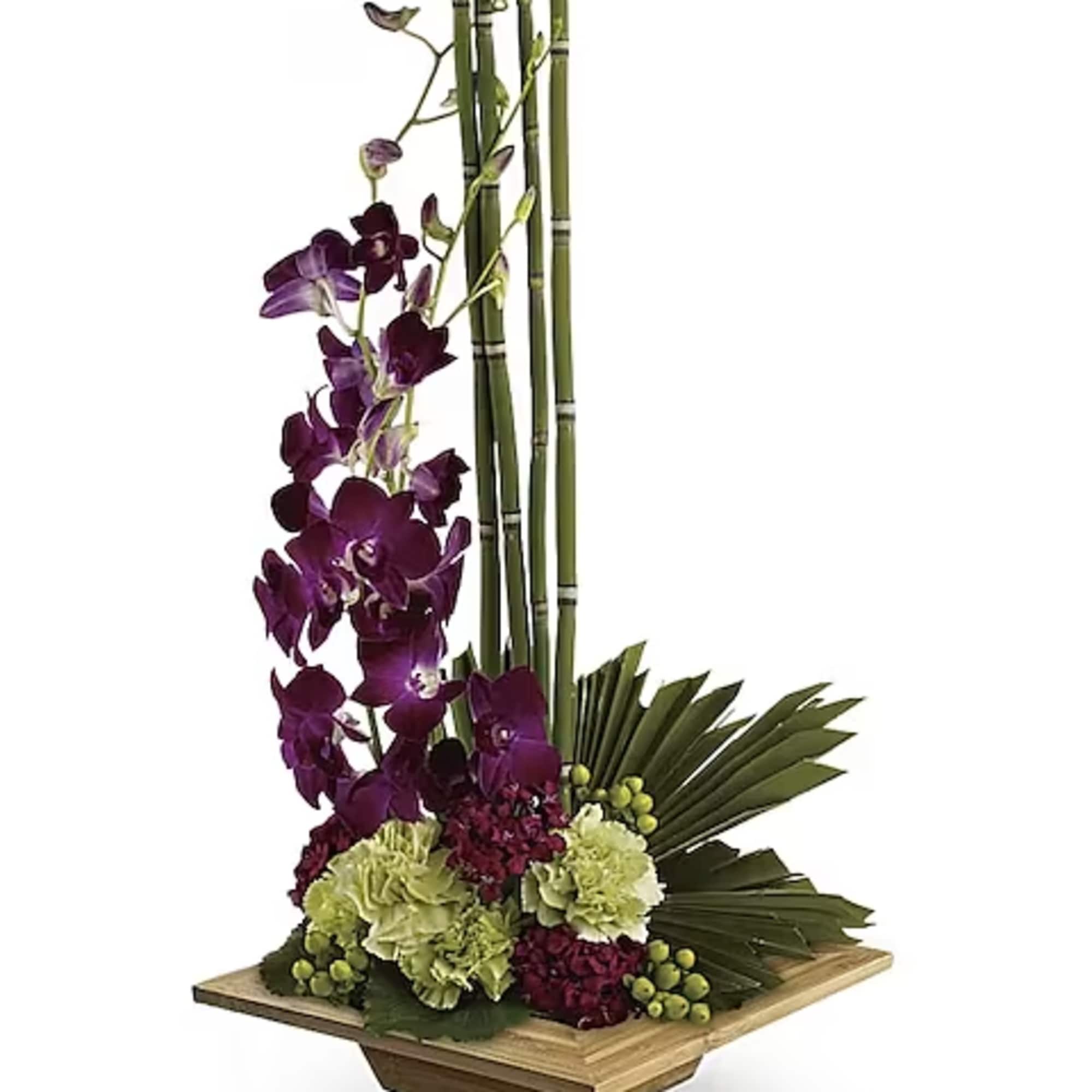 Tall orchid arrangement with bamboo stalks in a wooden base