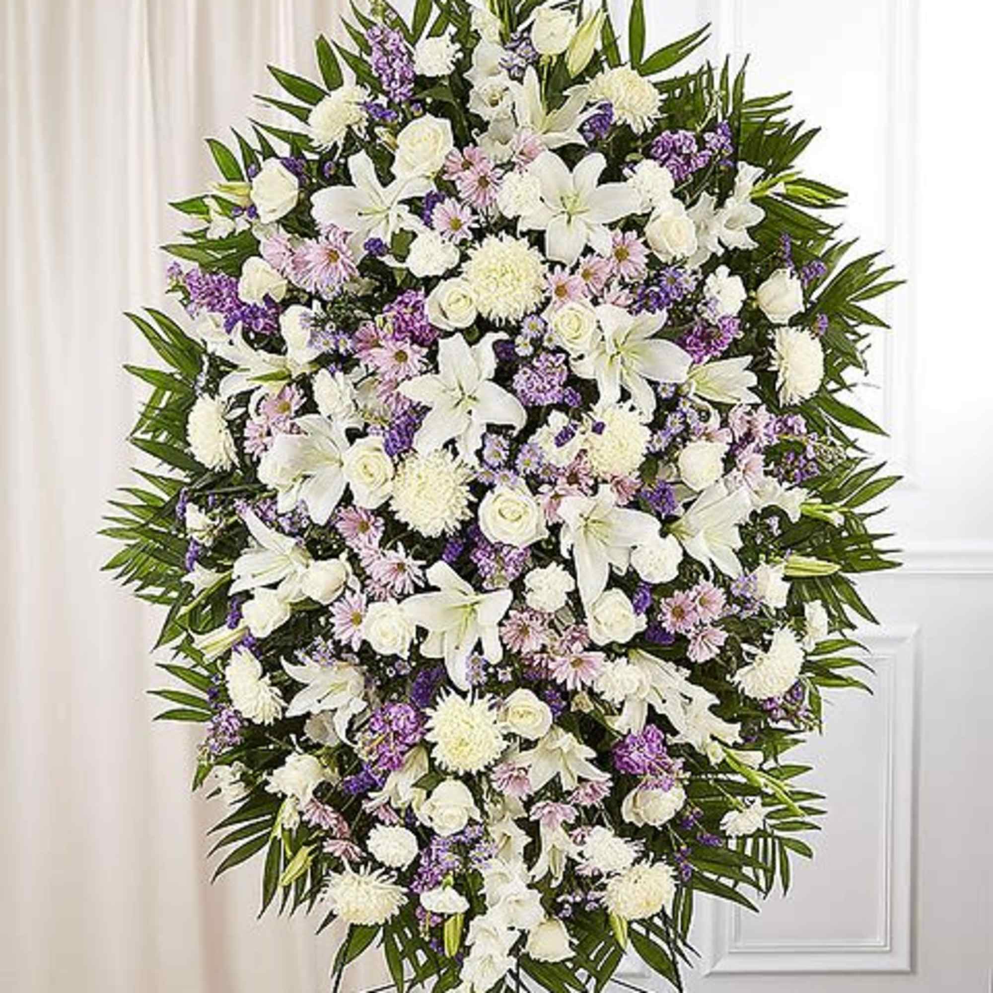 Large standing spray of white and lavender flowers on an easel