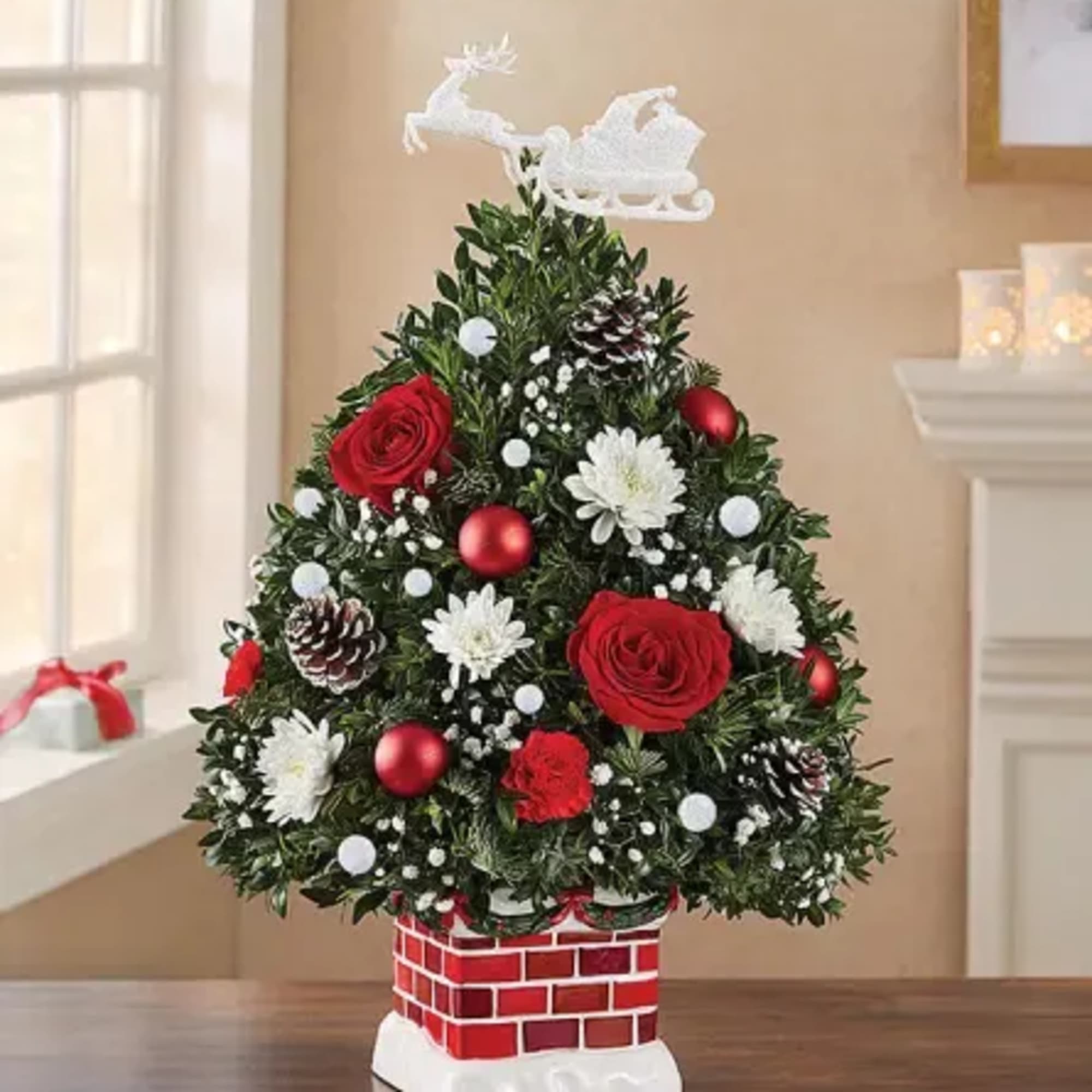 Christmas tree-shaped floral arrangement with red roses and white flowers