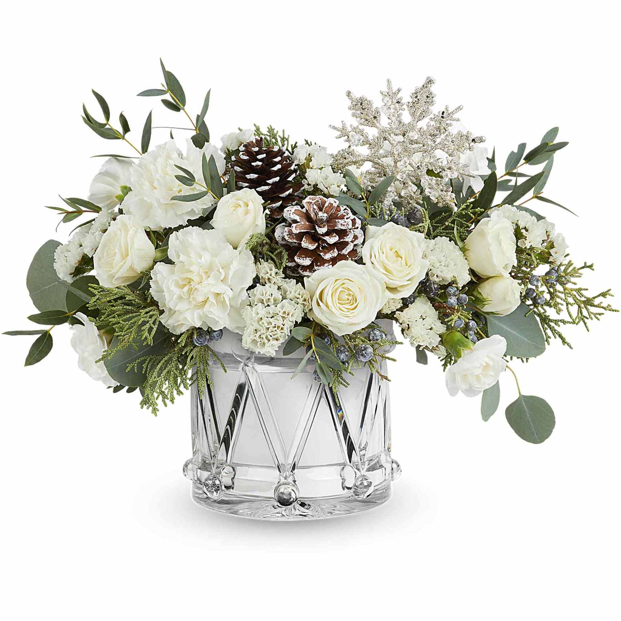 White floral arrangement in a clear glass vase with pinecones and greenery