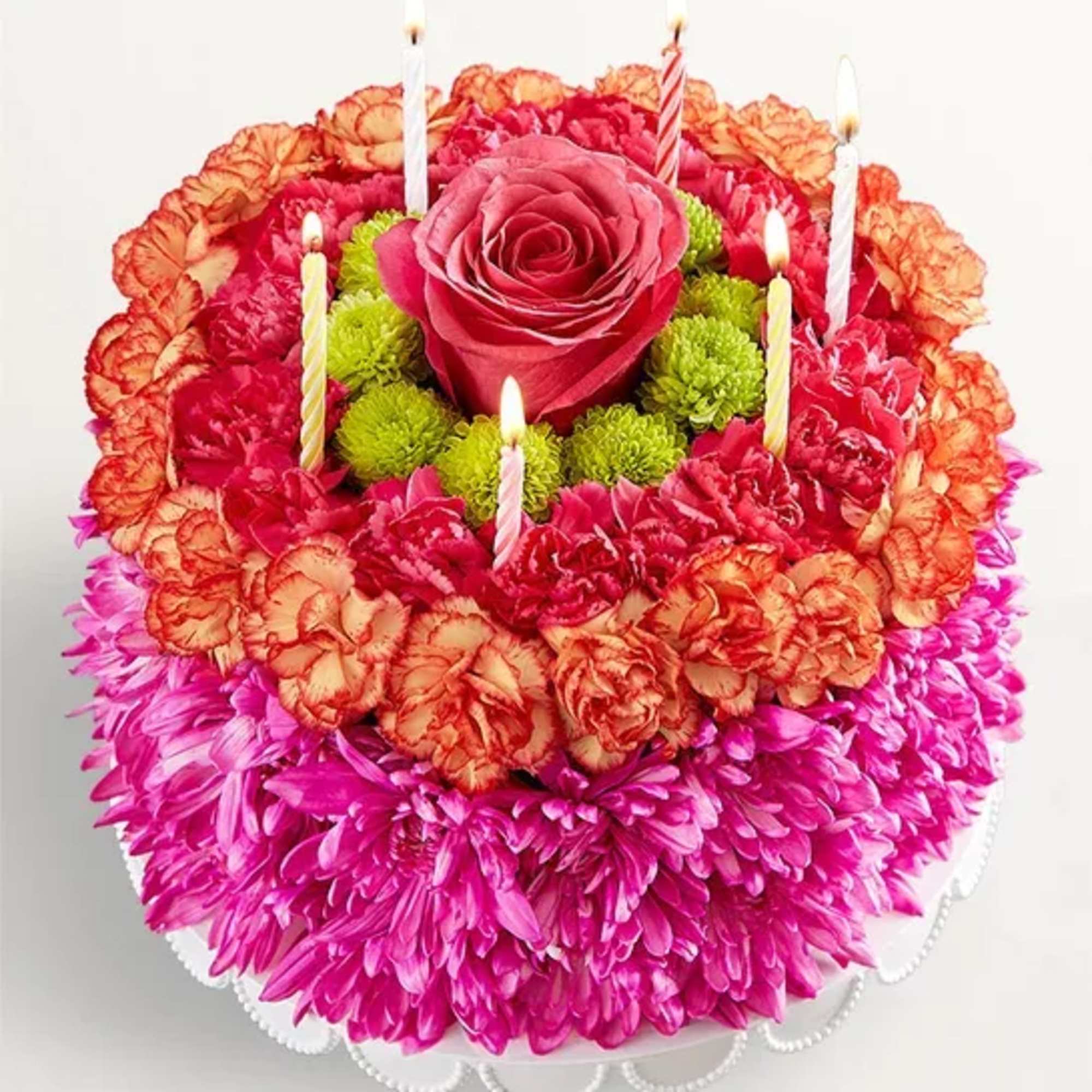 Round floral cake with candles and a pink rose center