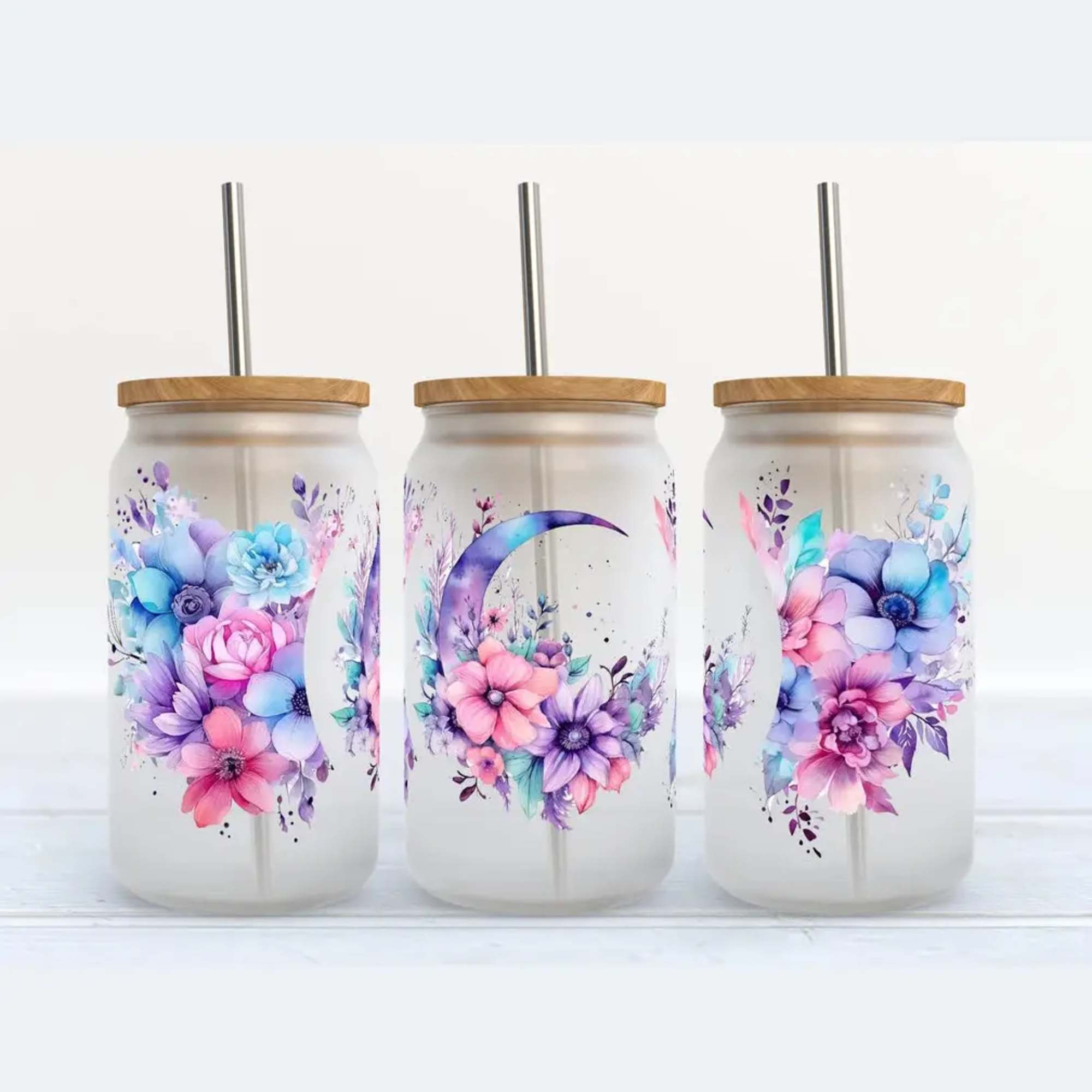 Three floral-print tumblers with lids and metal straws